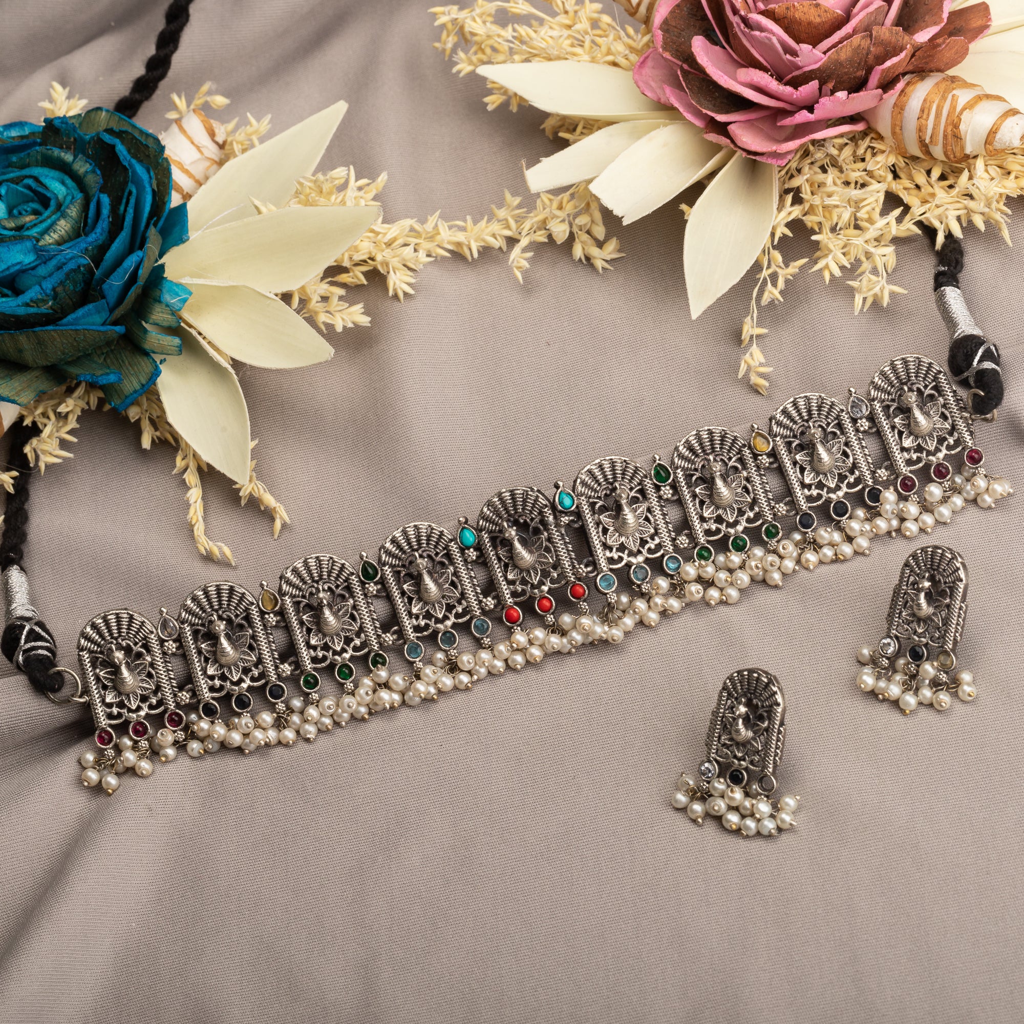 "Oxidized peacock choker with white pearls and colorful stones radiates vintage charm."