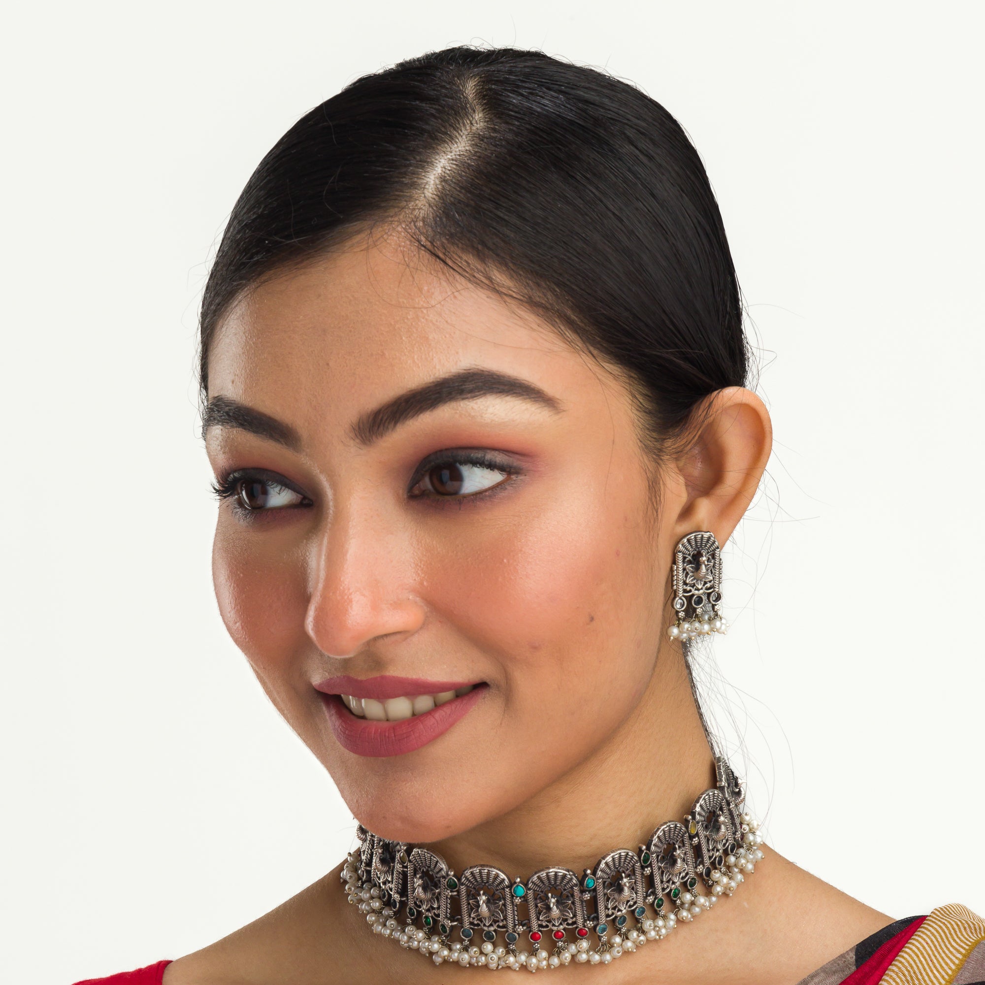 "Oxidized peacock choker with white pearls and colorful stones radiates vintage charm."