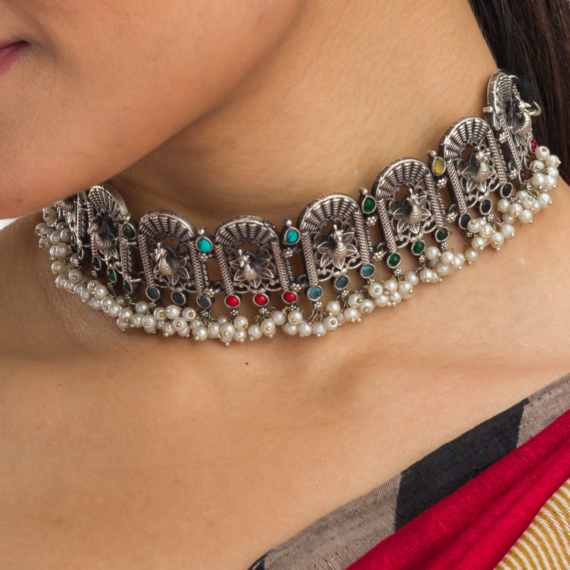 "Oxidized peacock choker with white pearls and colorful stones radiates vintage charm."