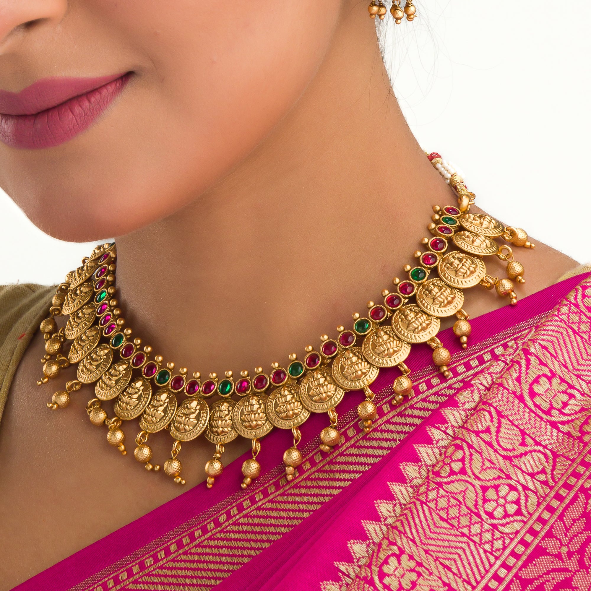 Coin-style gold-tone temple necklace exudes classic elegance and timeless tradition.
