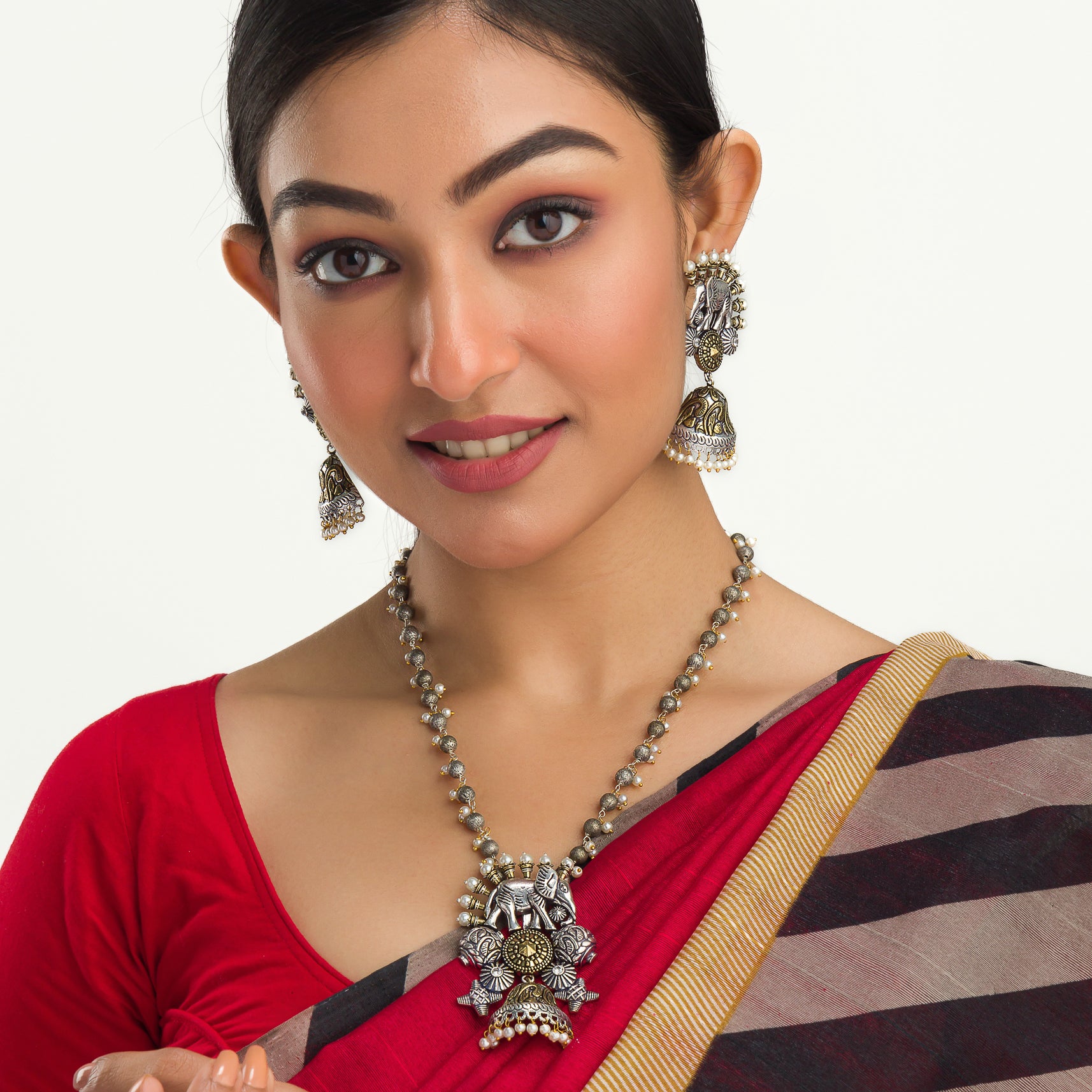 An oxidized dual-colour necklace with elephant and white pearls adds vintage charm and elegance.