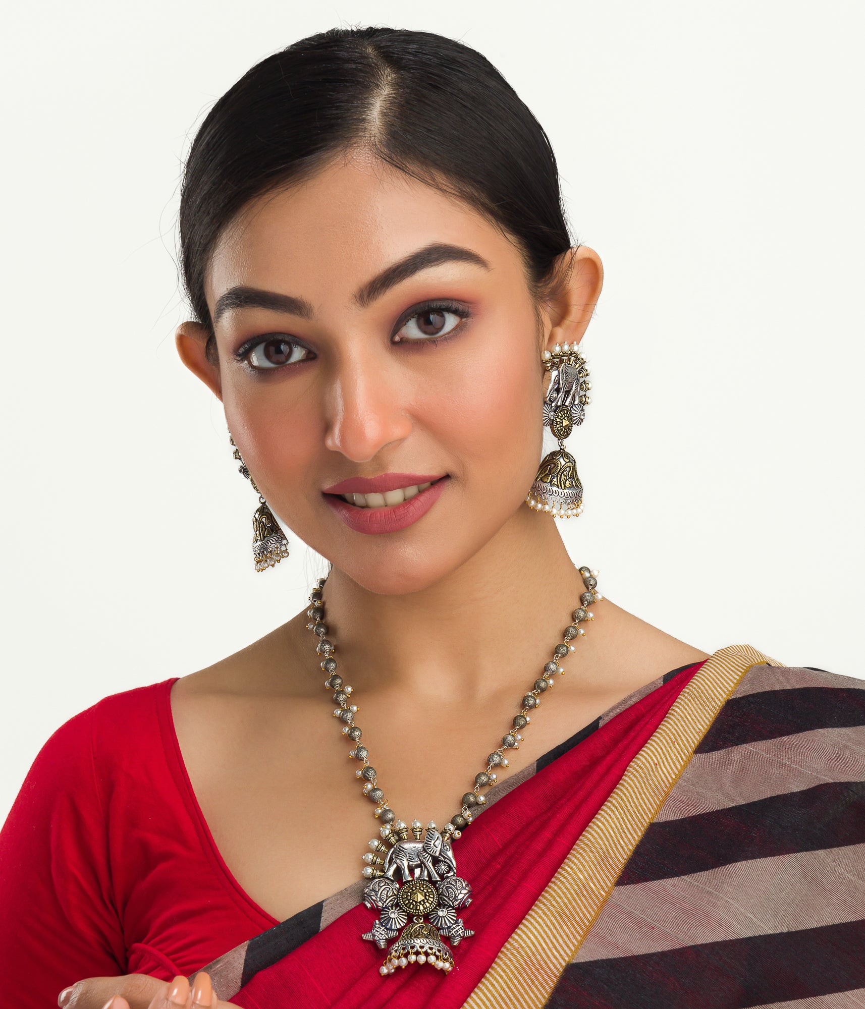 An oxidized dual-colour necklace with elephant and white pearls adds vintage charm and elegance.