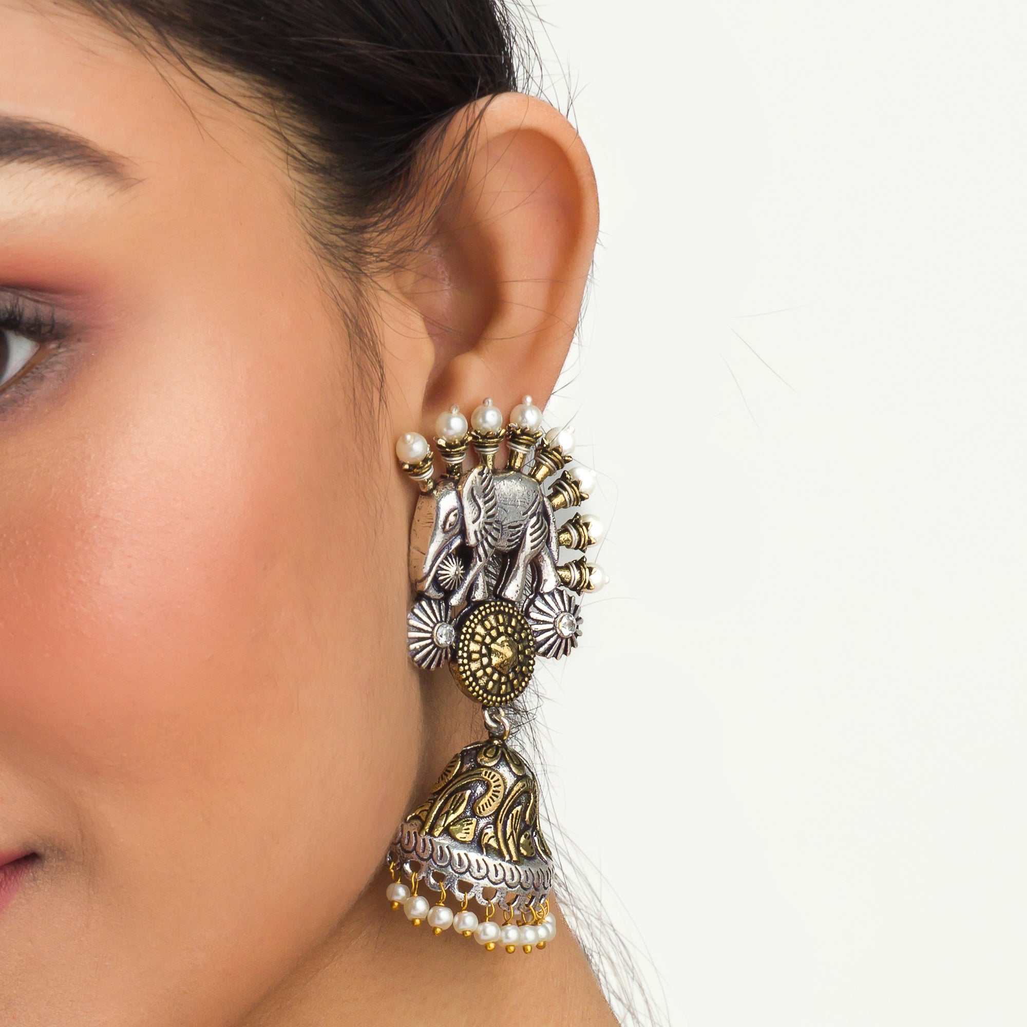 An oxidized dual-colour necklace with elephant and white pearls adds vintage charm and elegance.