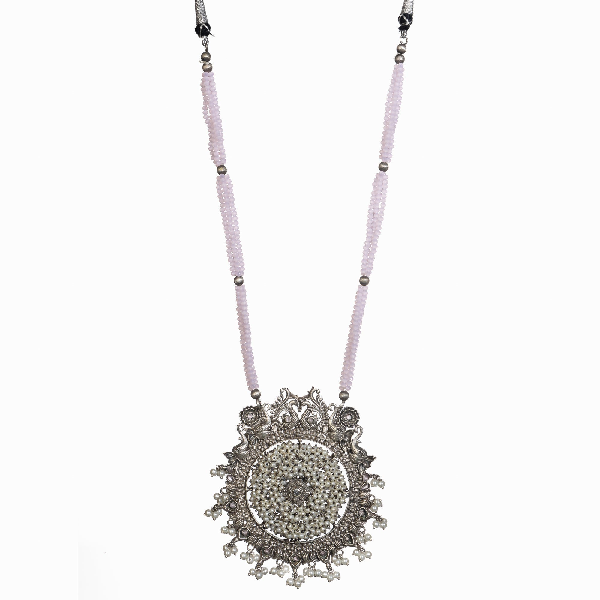 "Long oxidized necklace with pink and white pearls adds vintage elegance."