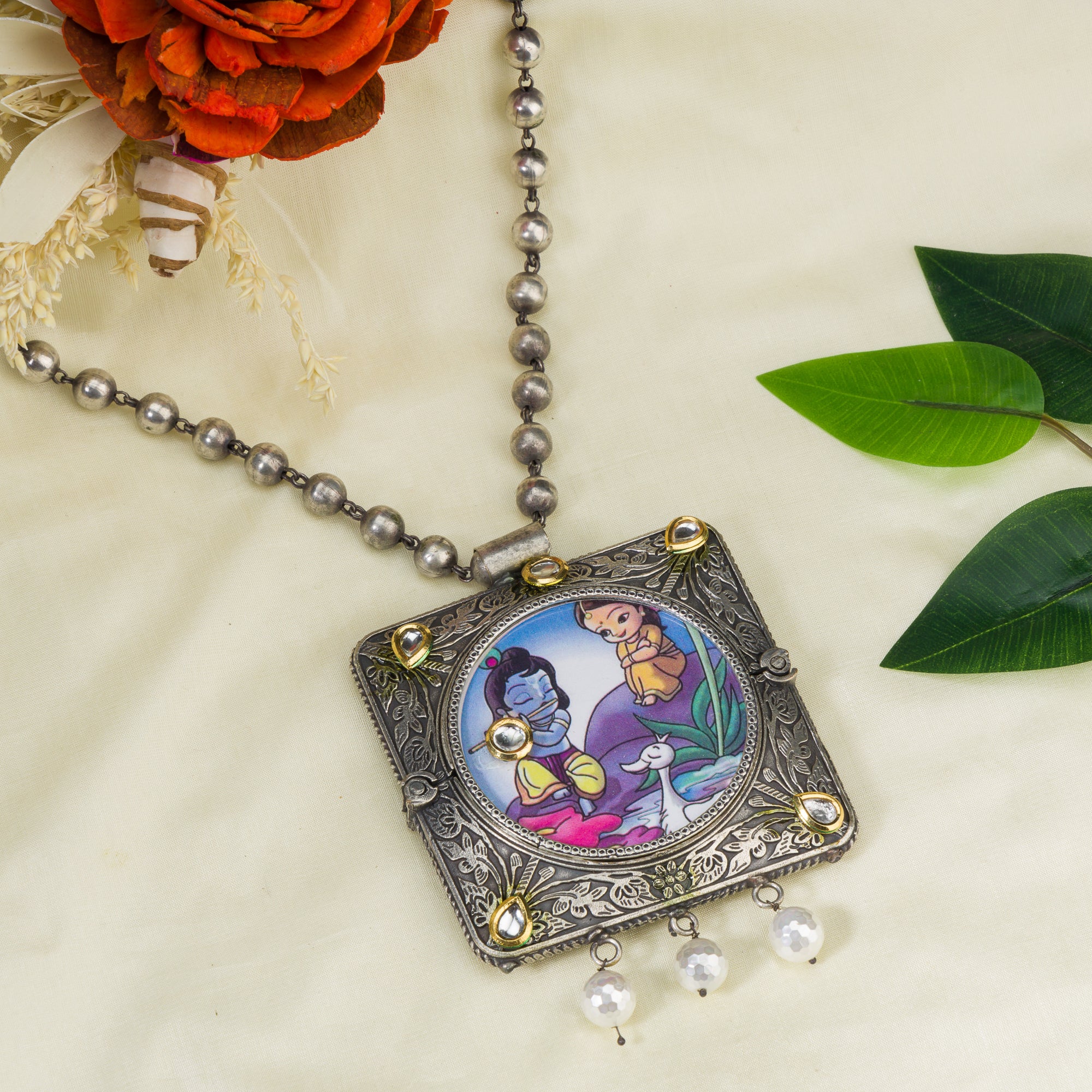 "Oxidized long necklace with Radha Krishna image brings spiritual charm."