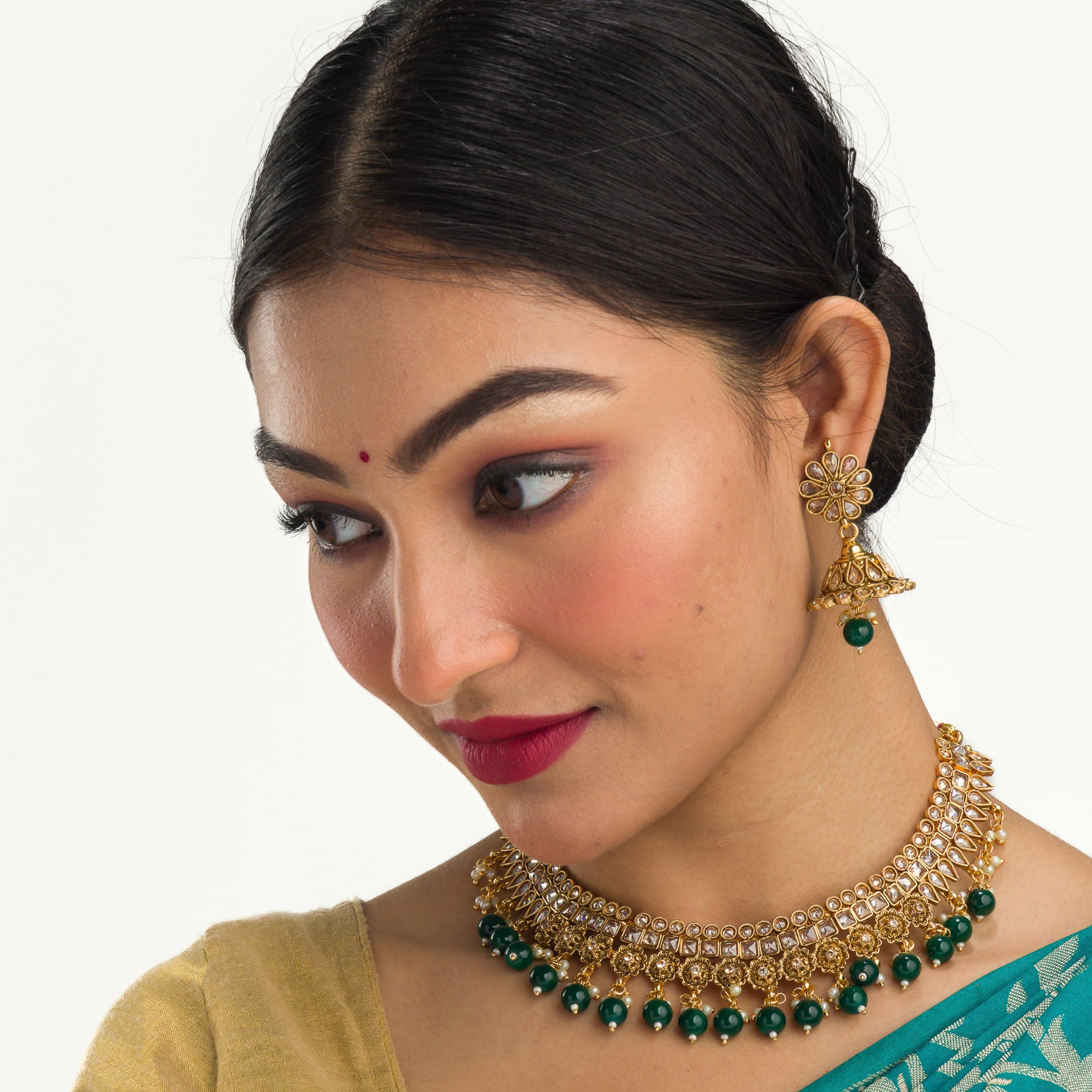 "Stylish gold-tone necklace with green Kundan for vibrant, elegant appeal."