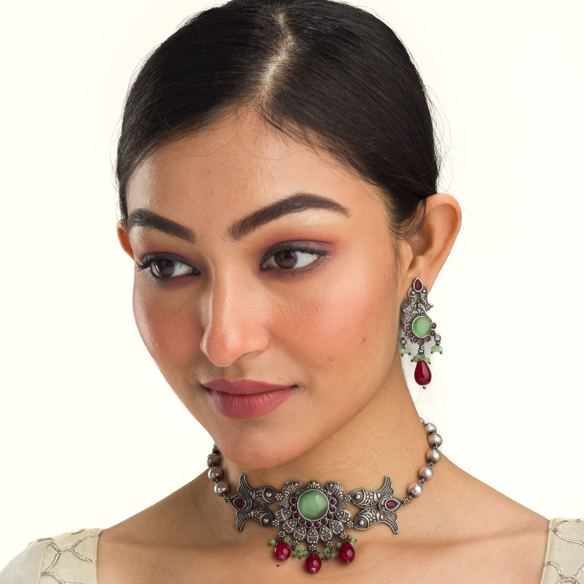 Oxidized choker with light green stones and maroon Kundan blends unique charm.