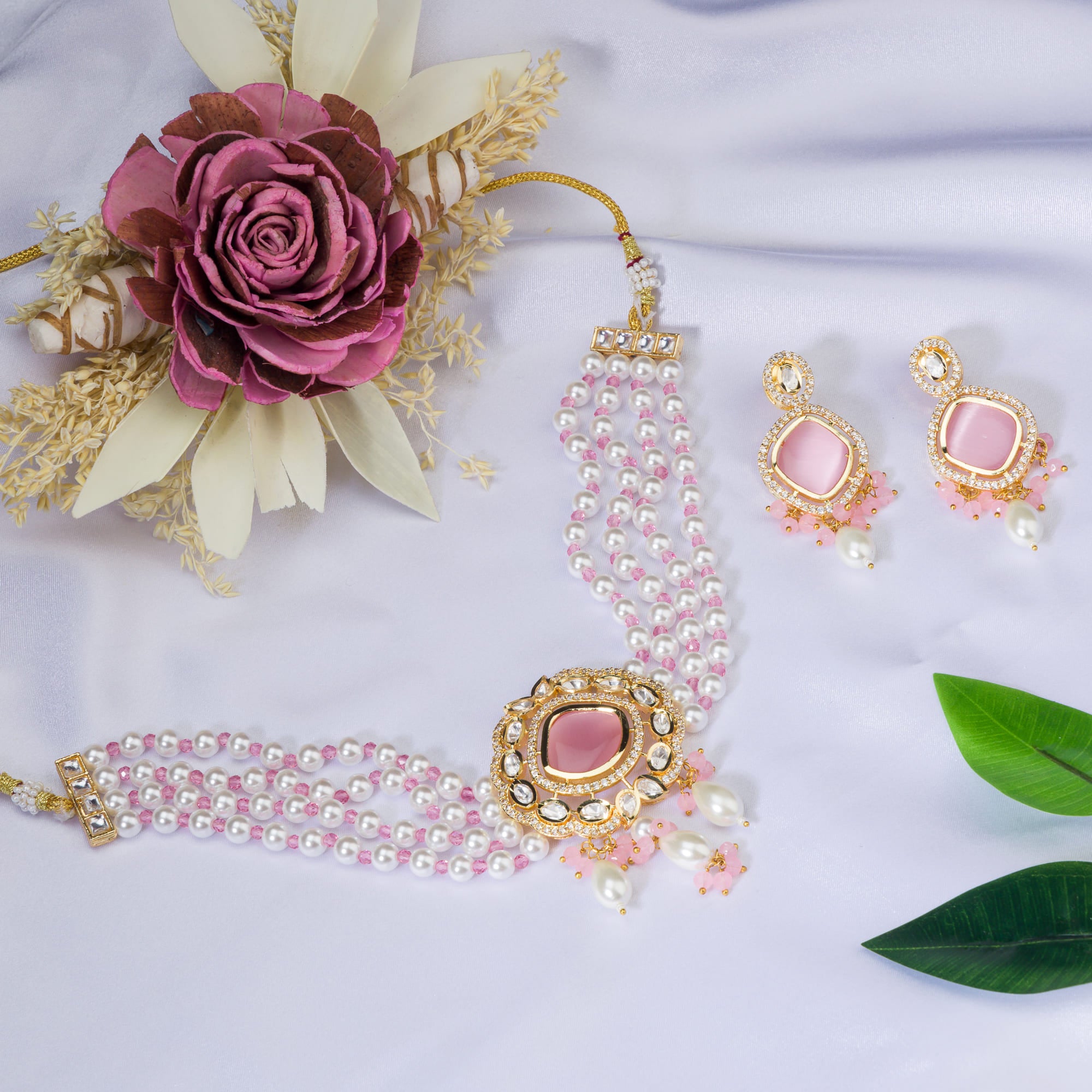 "White pearl necklace with a pink stone, combining classic and vibrant elegance."
