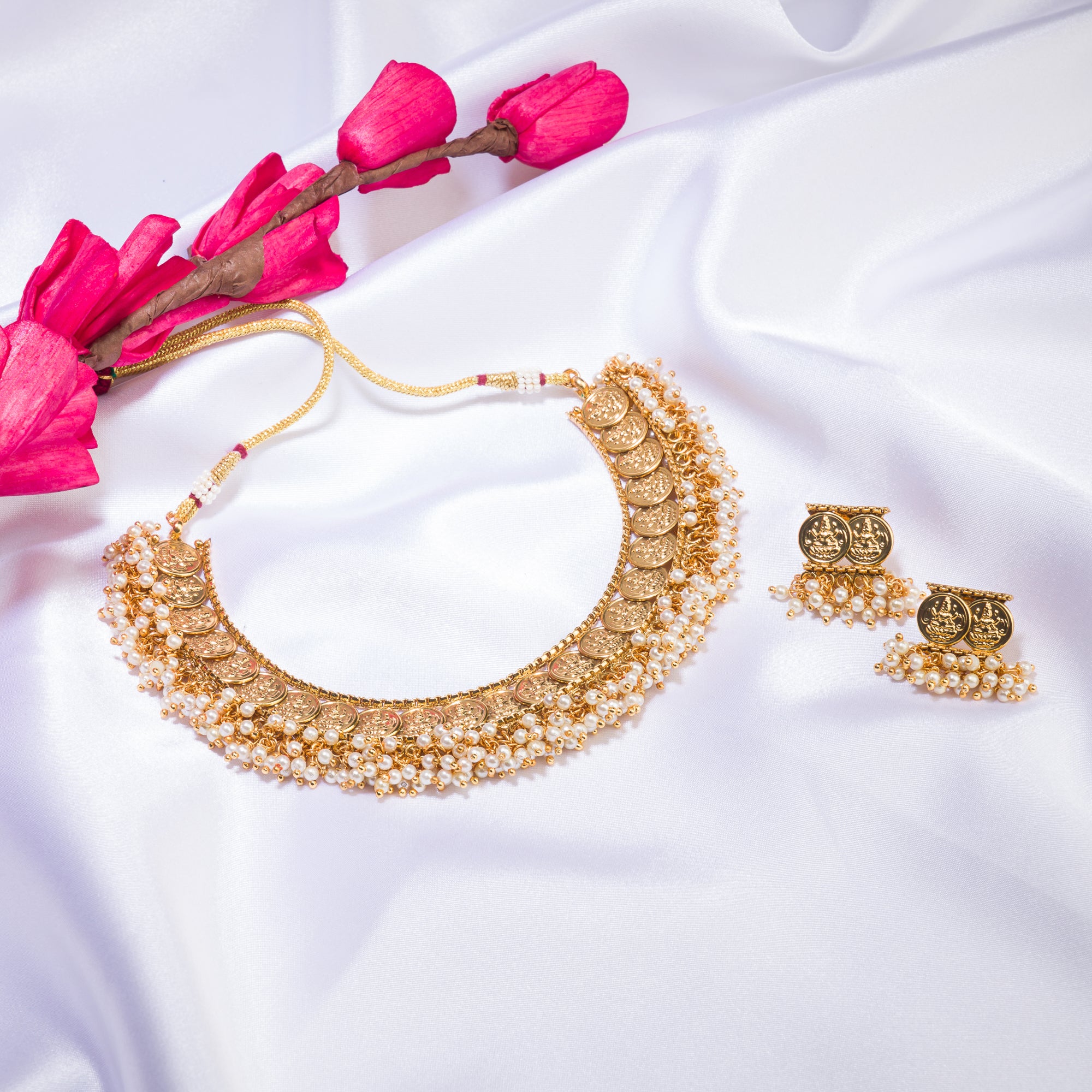 Gold-tone necklace with coin design and pearls exudes timeless elegance.