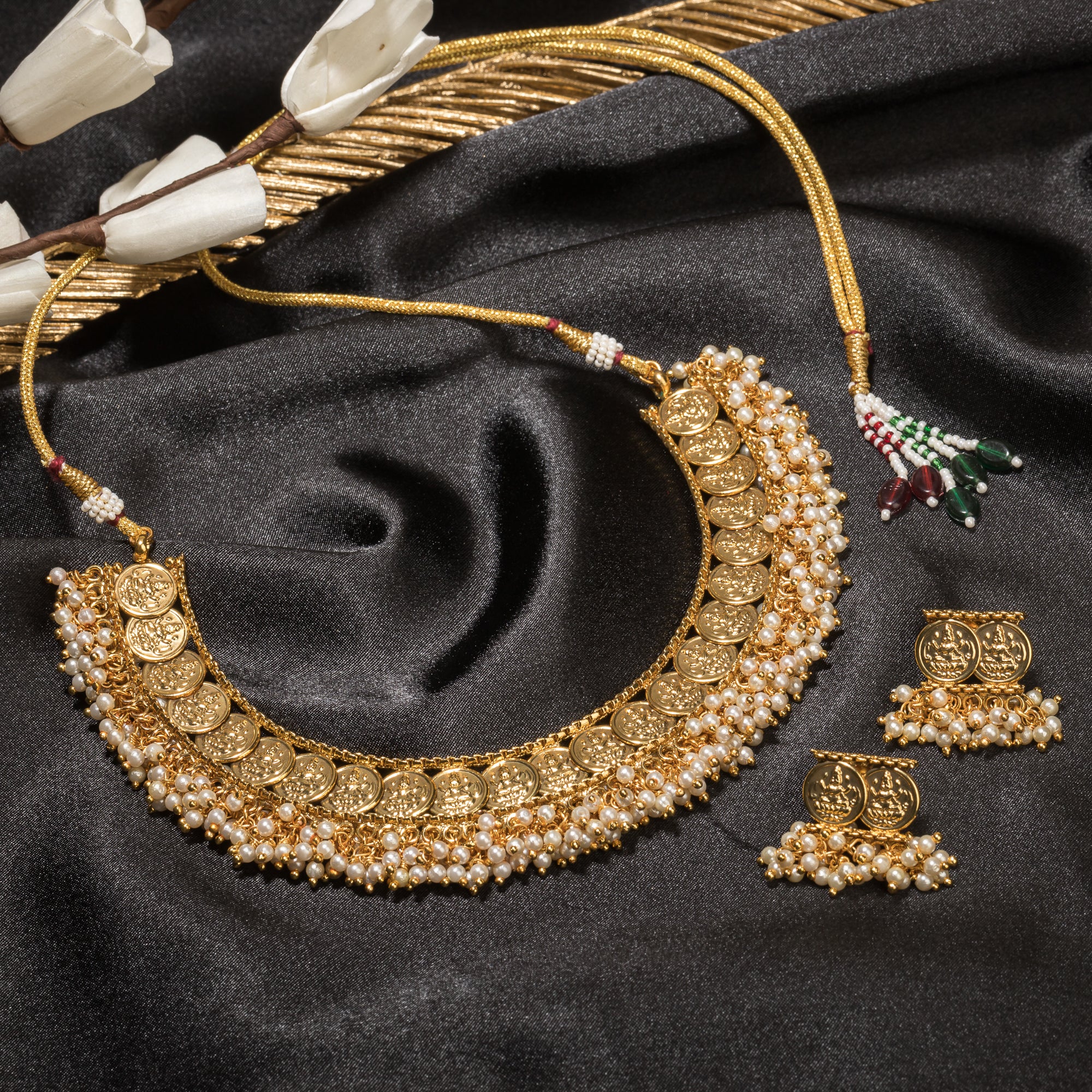 Gold-tone necklace with coin design and pearls exudes timeless elegance.