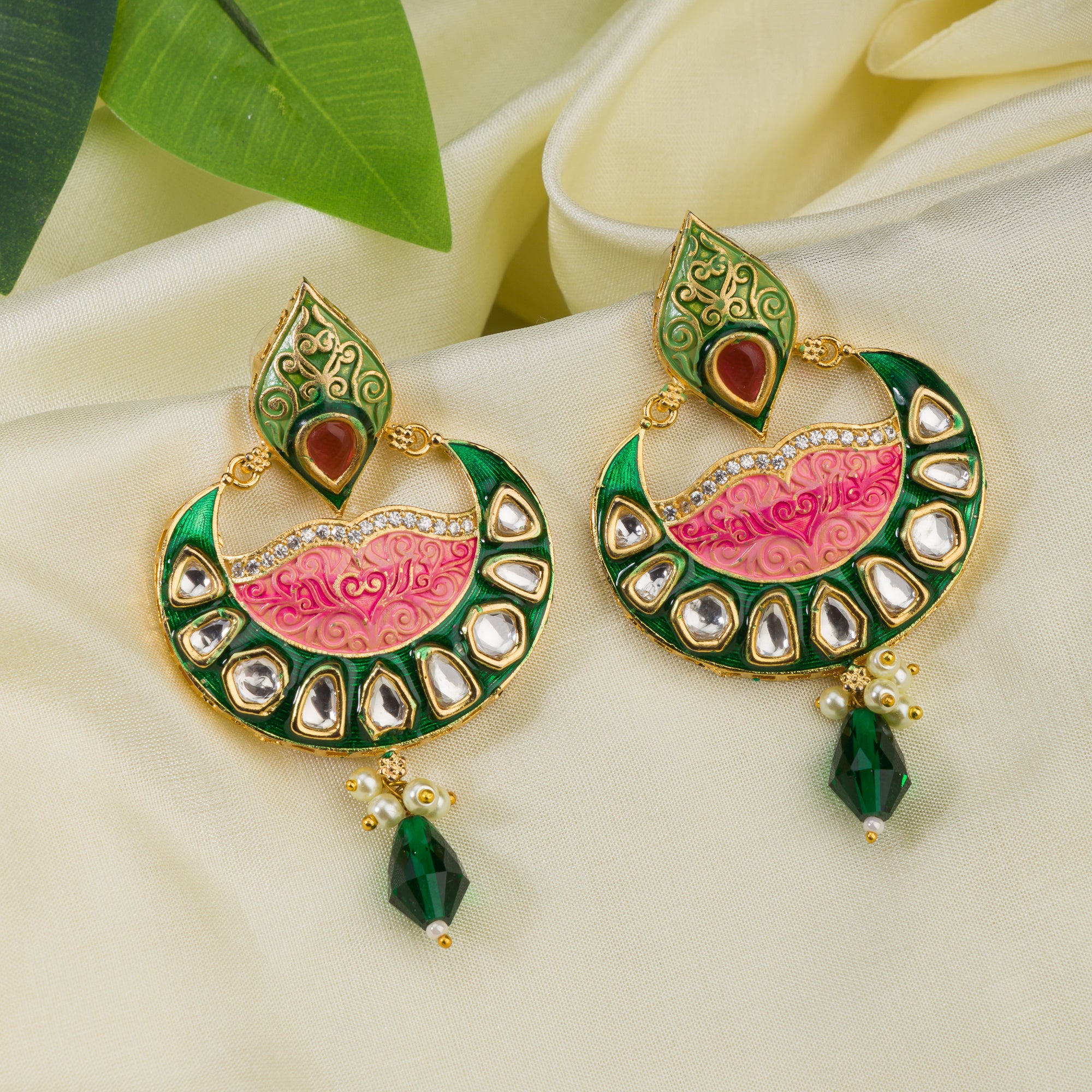 Green and pink Meenakari earrings feature colorful enamel for a traditional look.
