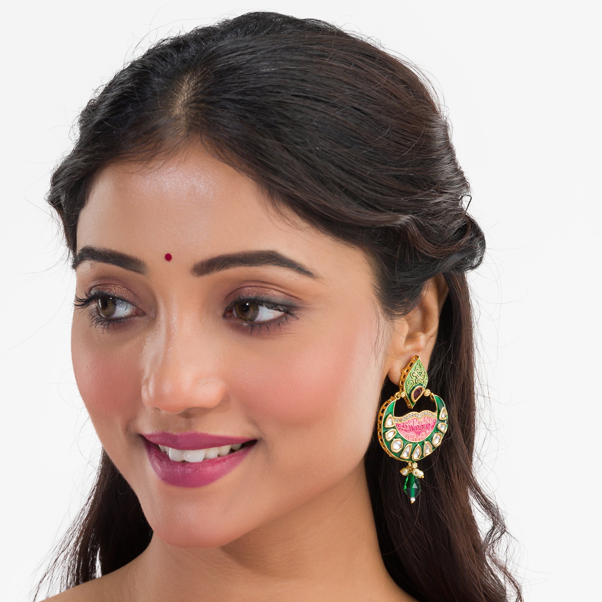 Green and pink Meenakari earrings feature colorful enamel for a traditional look.