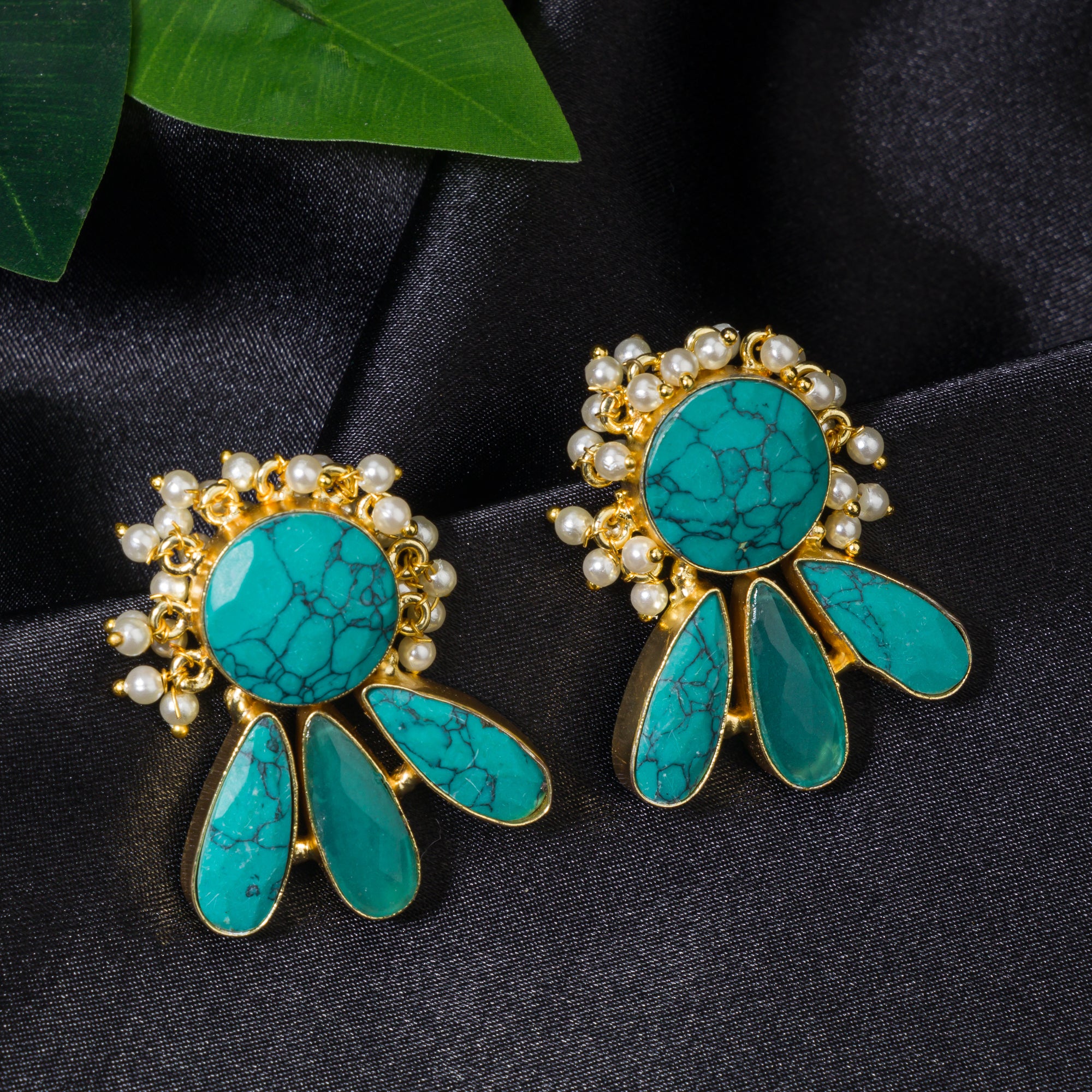 Blue gold-tone earrings with a pearl drop offer classic elegance and vibrant color.