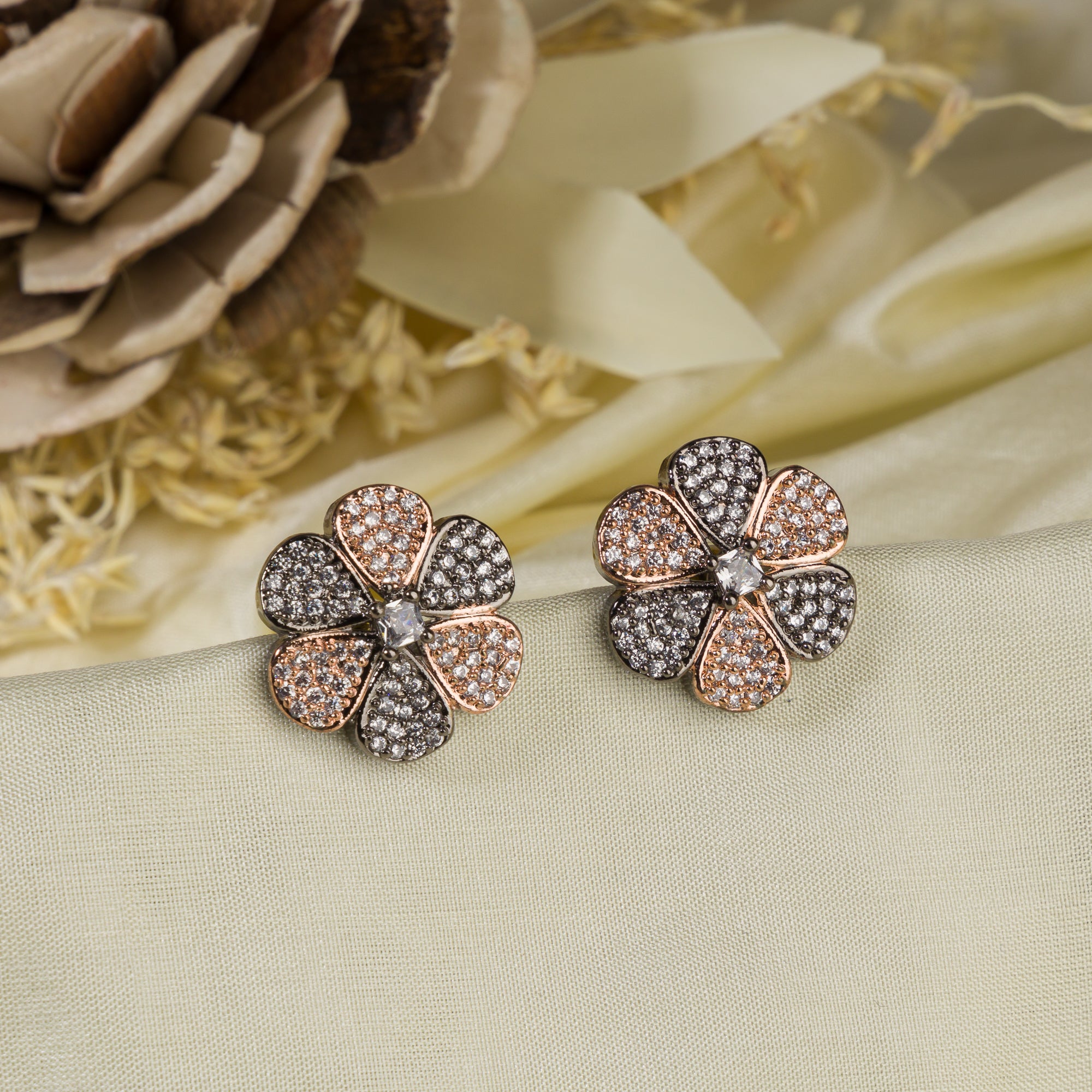 "Zircon flower-shaped earrings with rose gold polish combine warmth and vibrant sparkle."