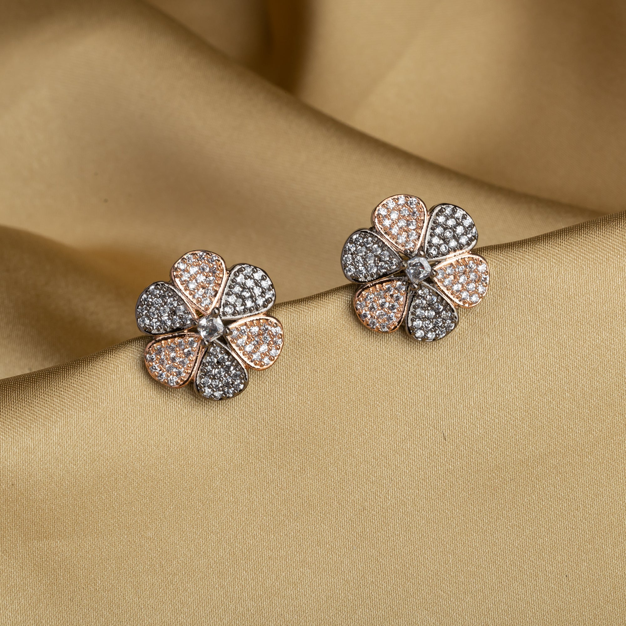 "Zircon flower-shaped earrings with rose gold polish combine warmth and vibrant sparkle."