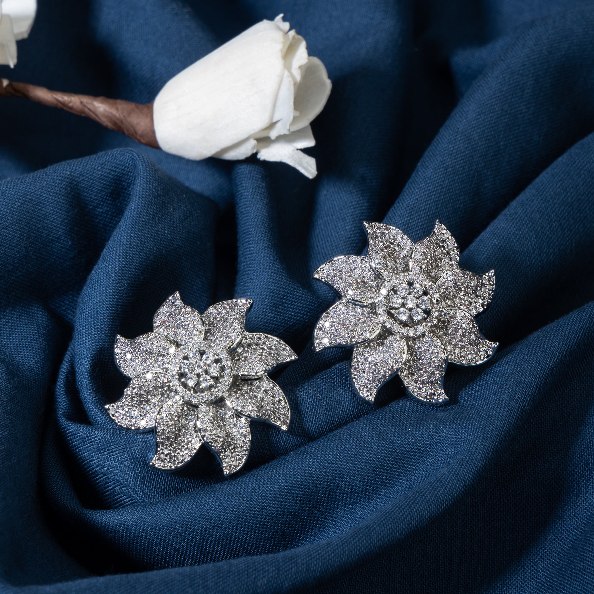 Flowery zircon stud earrings offer charming elegance with sparkling grace for a refined look.