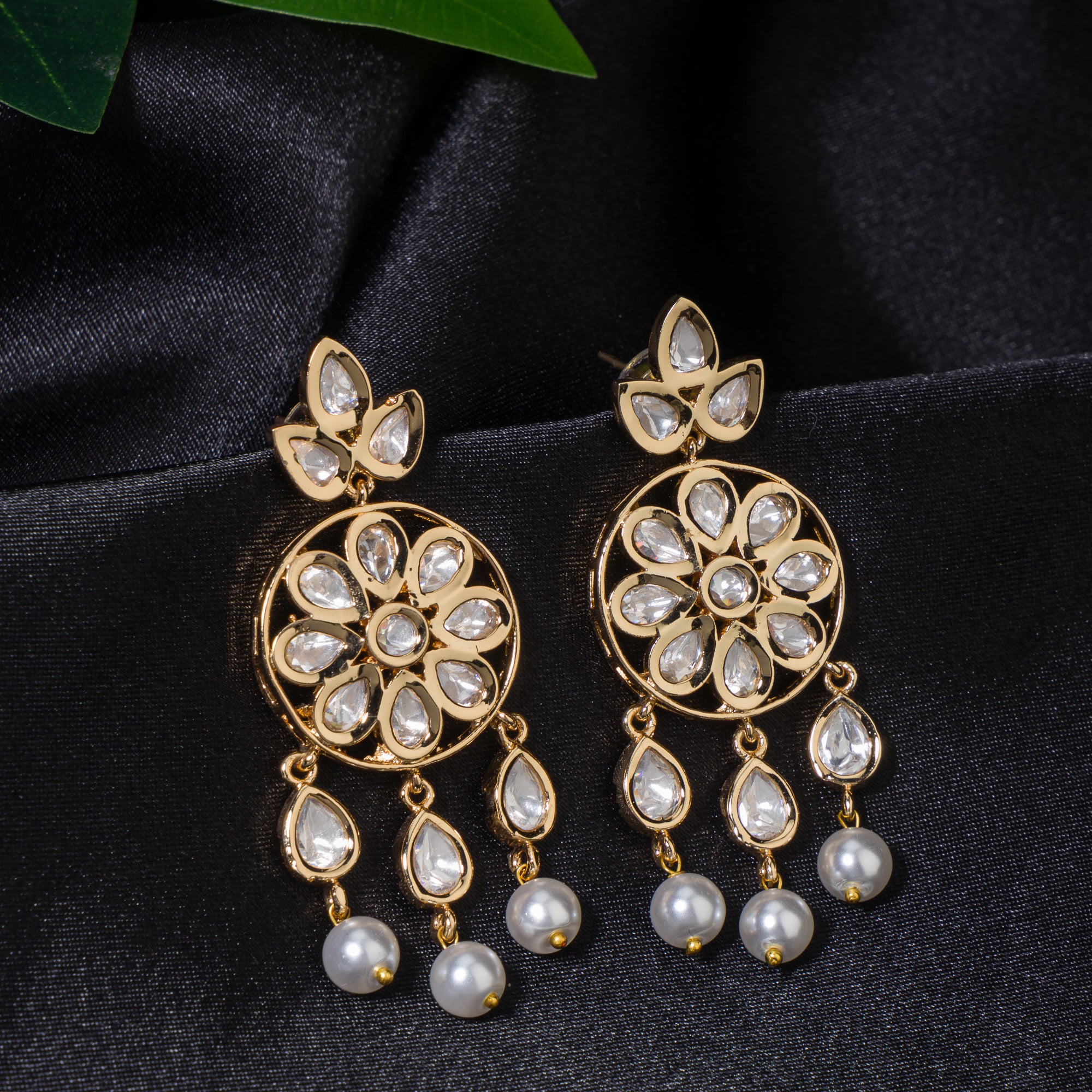 Small gold-tone dangler earrings with white pearls, adding delicate sophistication.