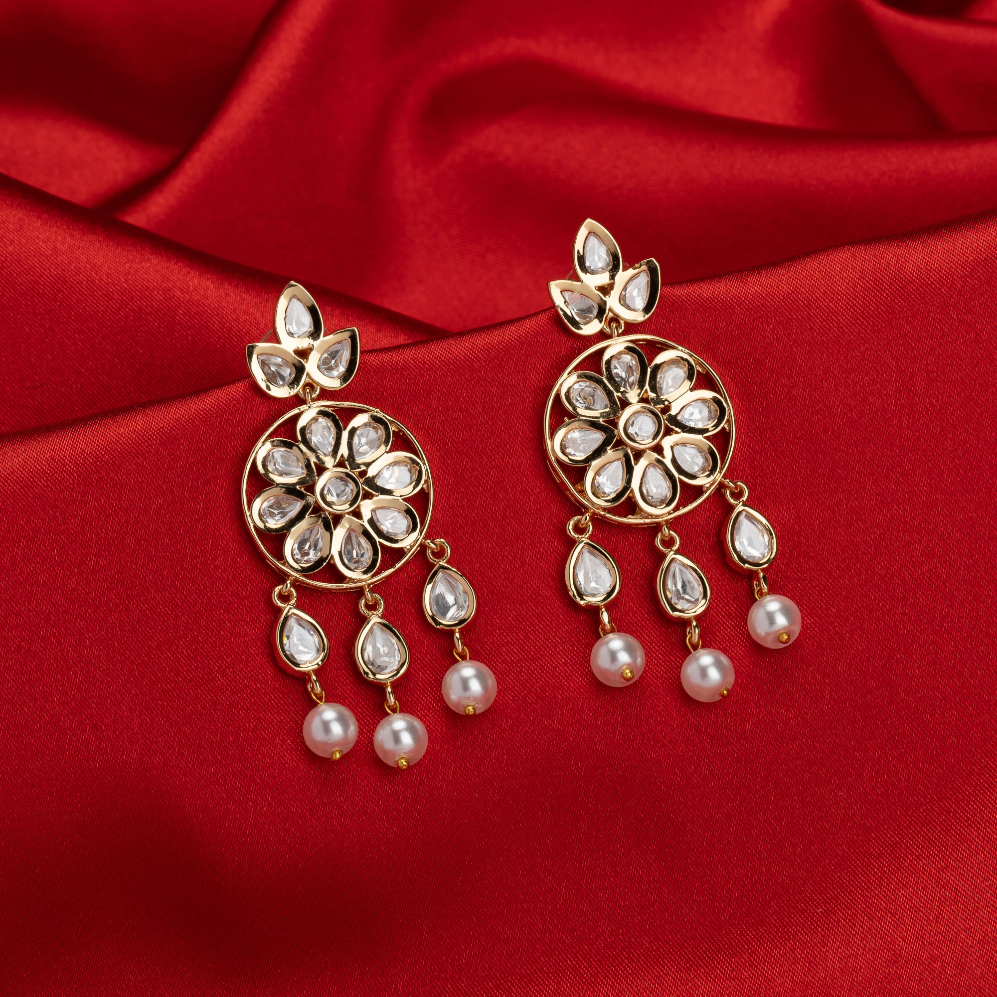 Small gold-tone dangler earrings with white pearls, adding delicate sophistication.