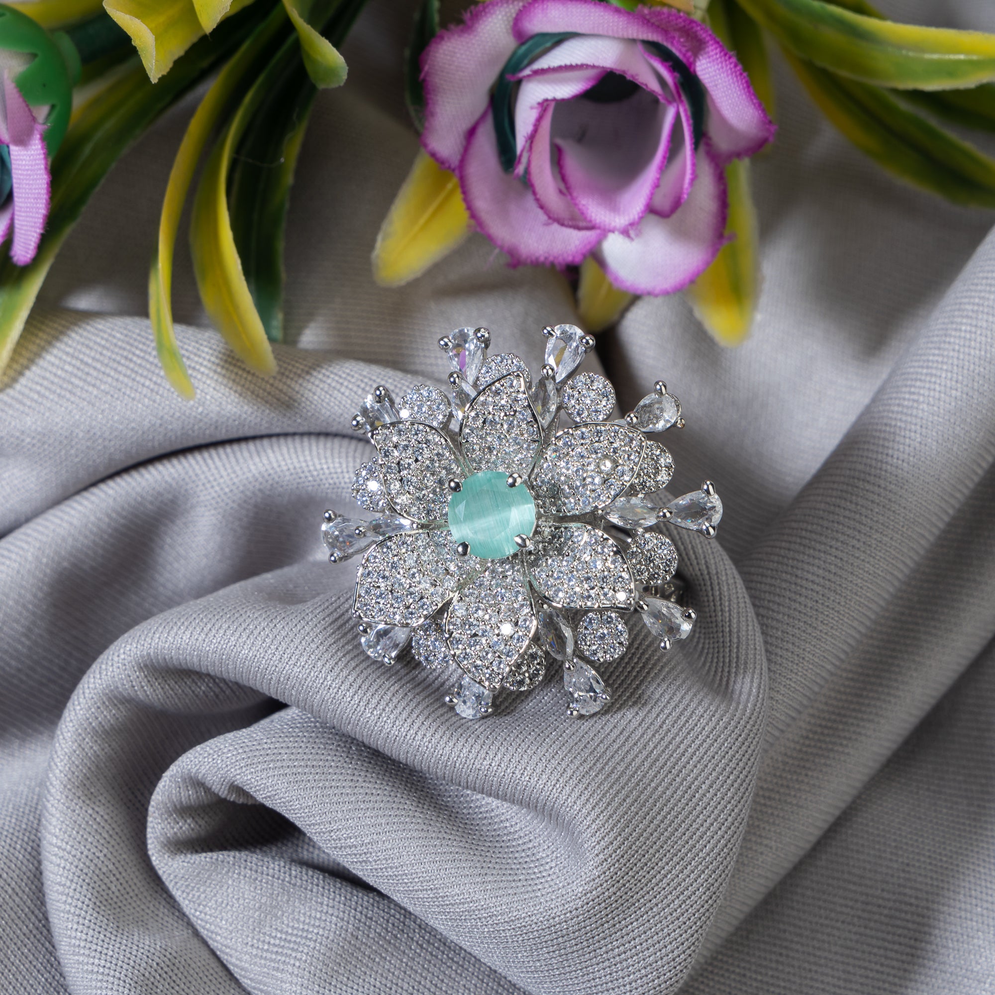 Aqua zircon floral finger ring in silver brings a fresh, vibrant charm to your party style.