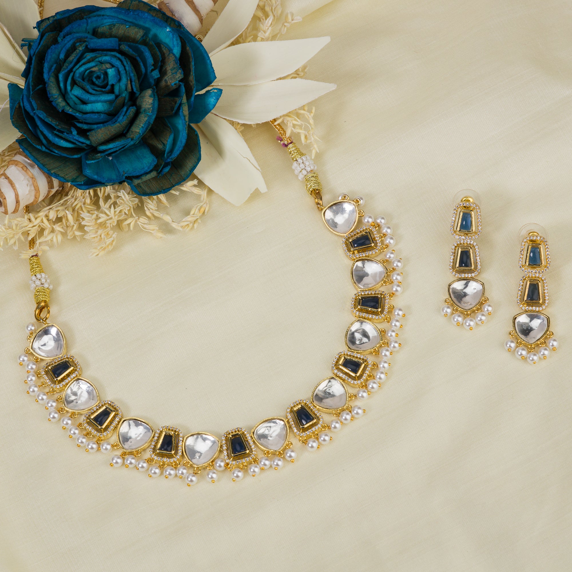 Black polished necklace set with golden, white zircon stones, and pearls for a striking elegant look.