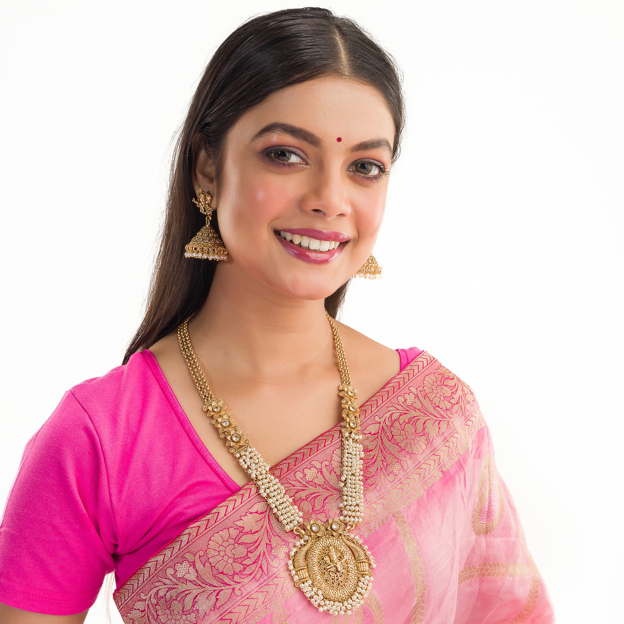 Golden Radha Krishna long necklace set with pearls and matching jhumkas for a divine festive look.