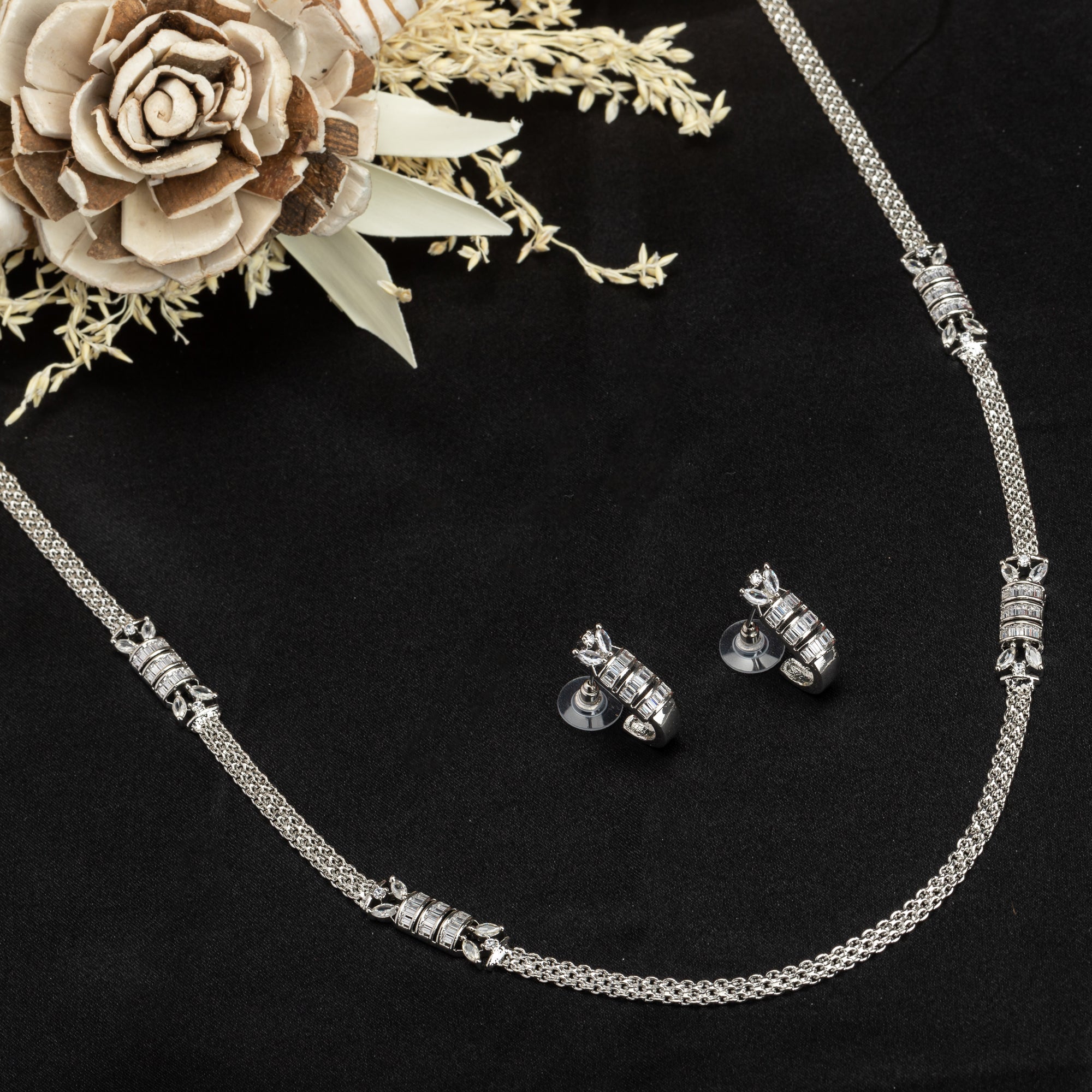 Silver pendant with white zircon stones and matching earrings for a sparkling party look.