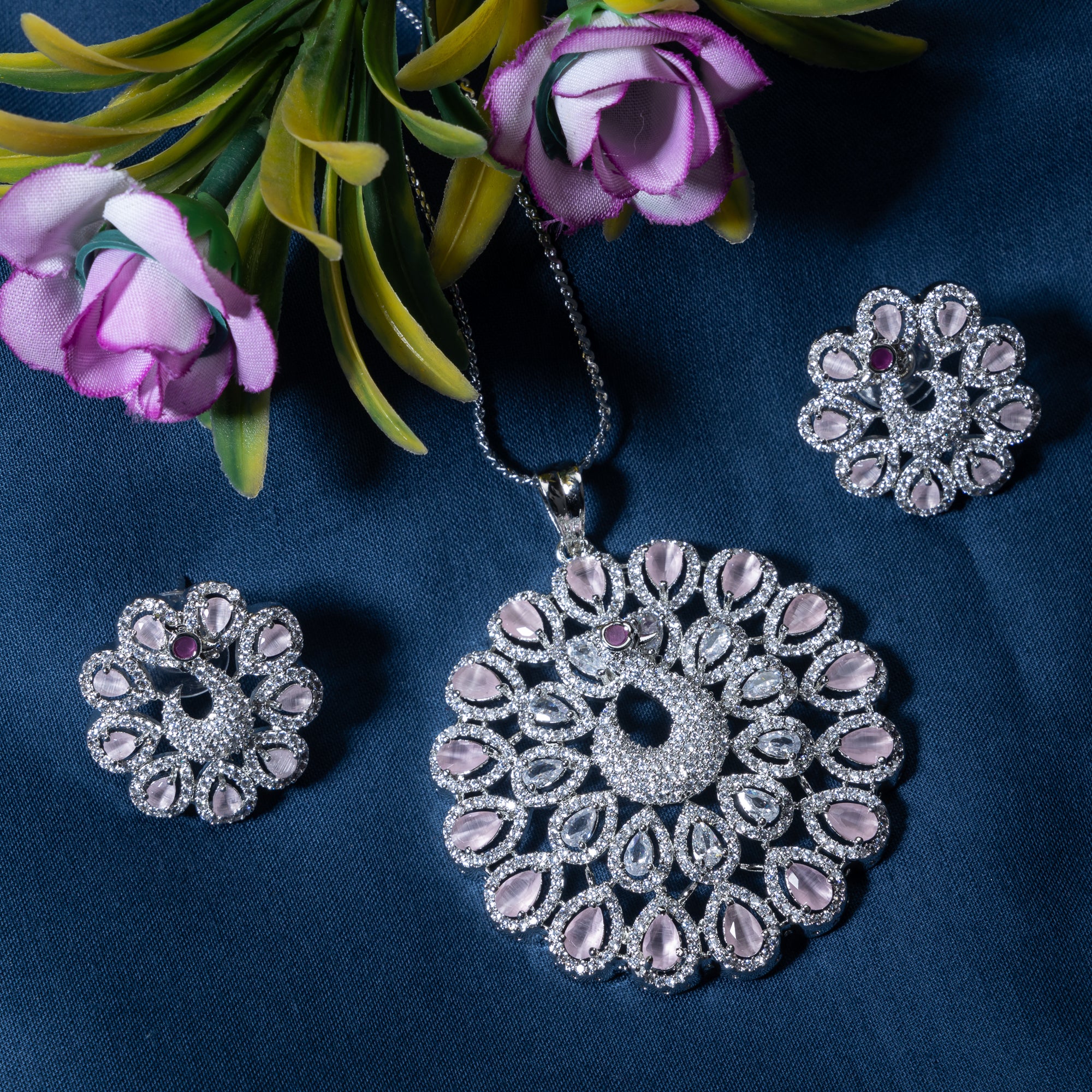 A peacock-designed pendant set with turquoise and white zircon stones is paired with matching earrings.