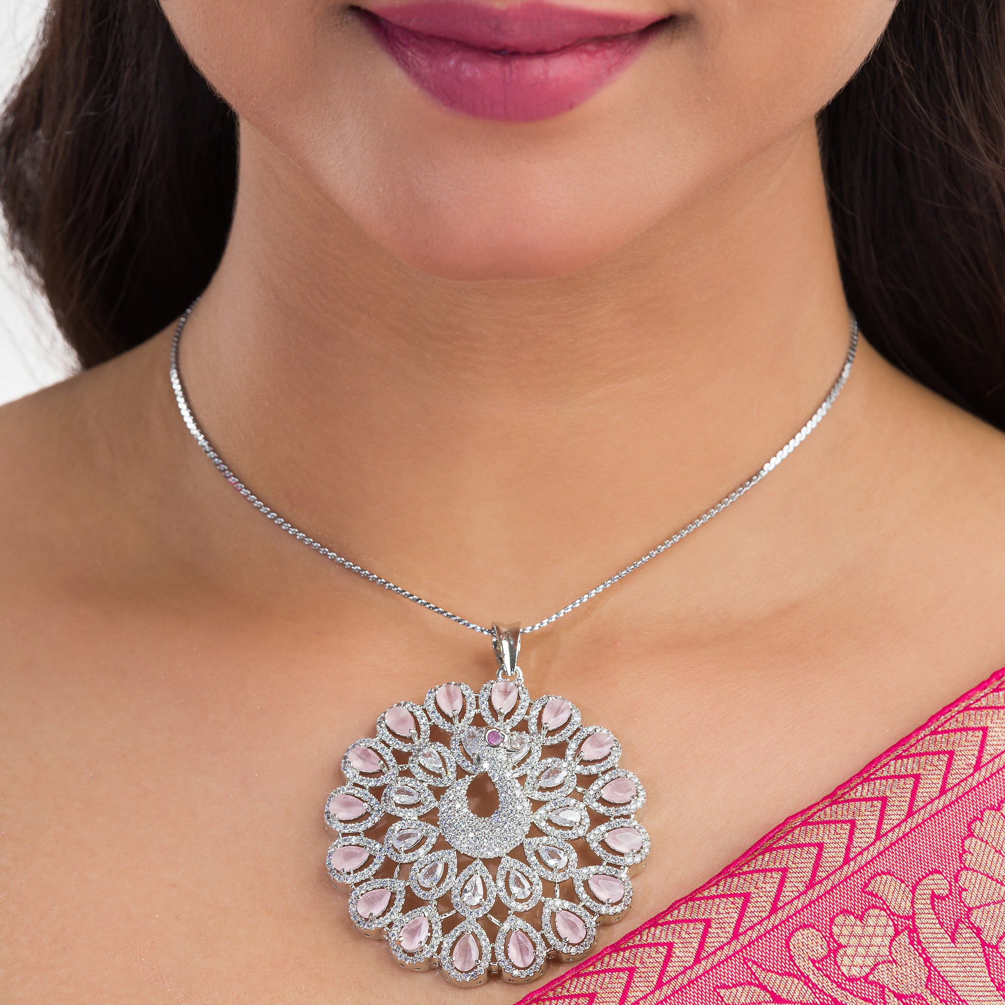 A peacock-designed pendant set with turquoise and white zircon stones is paired with matching earrings.