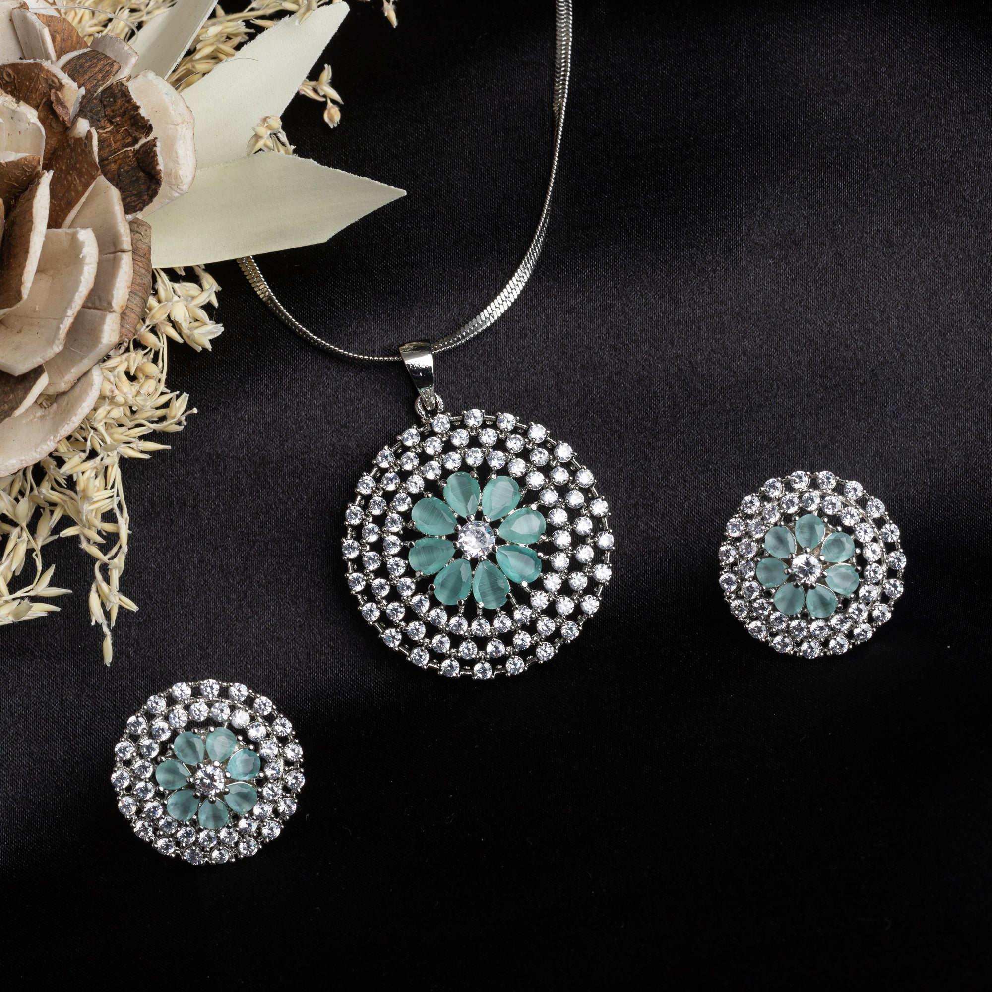 Floral zircon pendant set with turquoise and white stones, paired with matching earrings.
