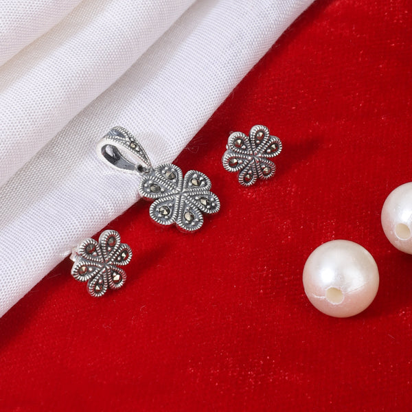 "925 silver pendant and earrings set with floral design, exuding elegance and sophistication."