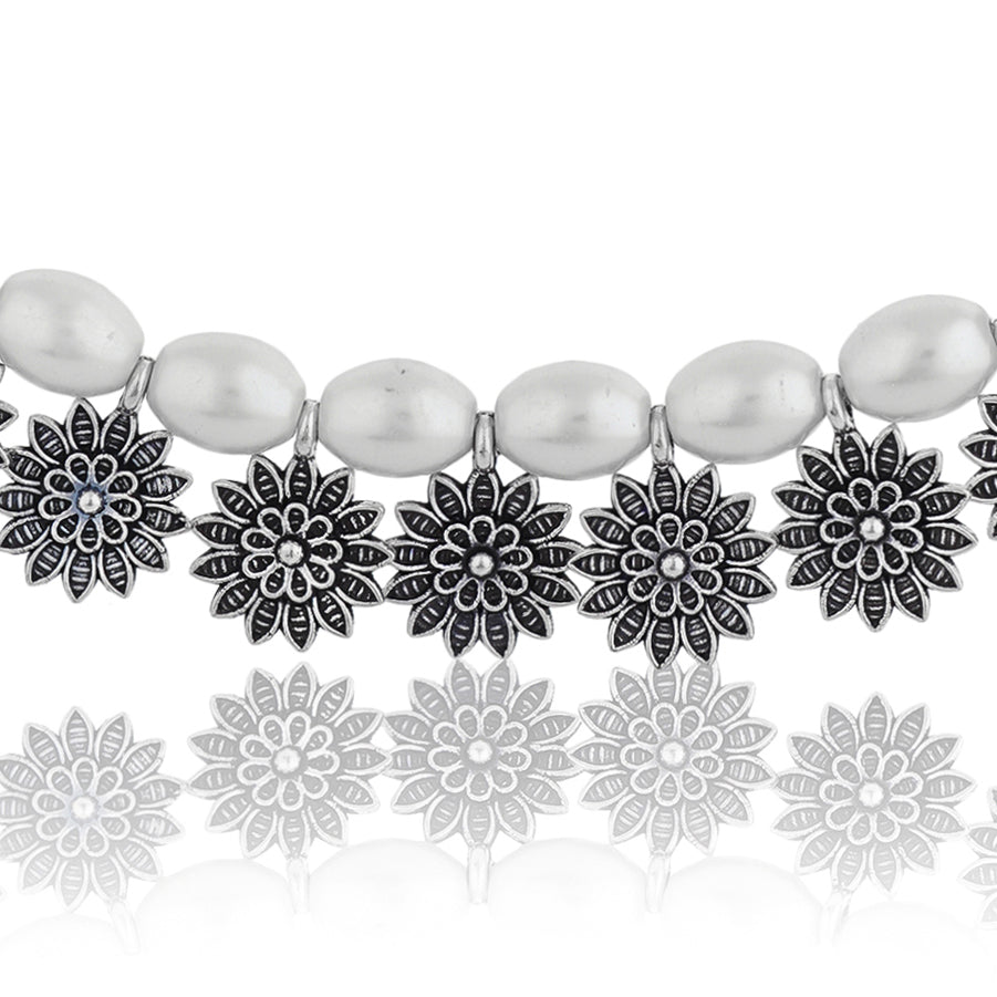 Stylish oxidized choker with floral design and white pearls, adding vintage charm to festive looks.