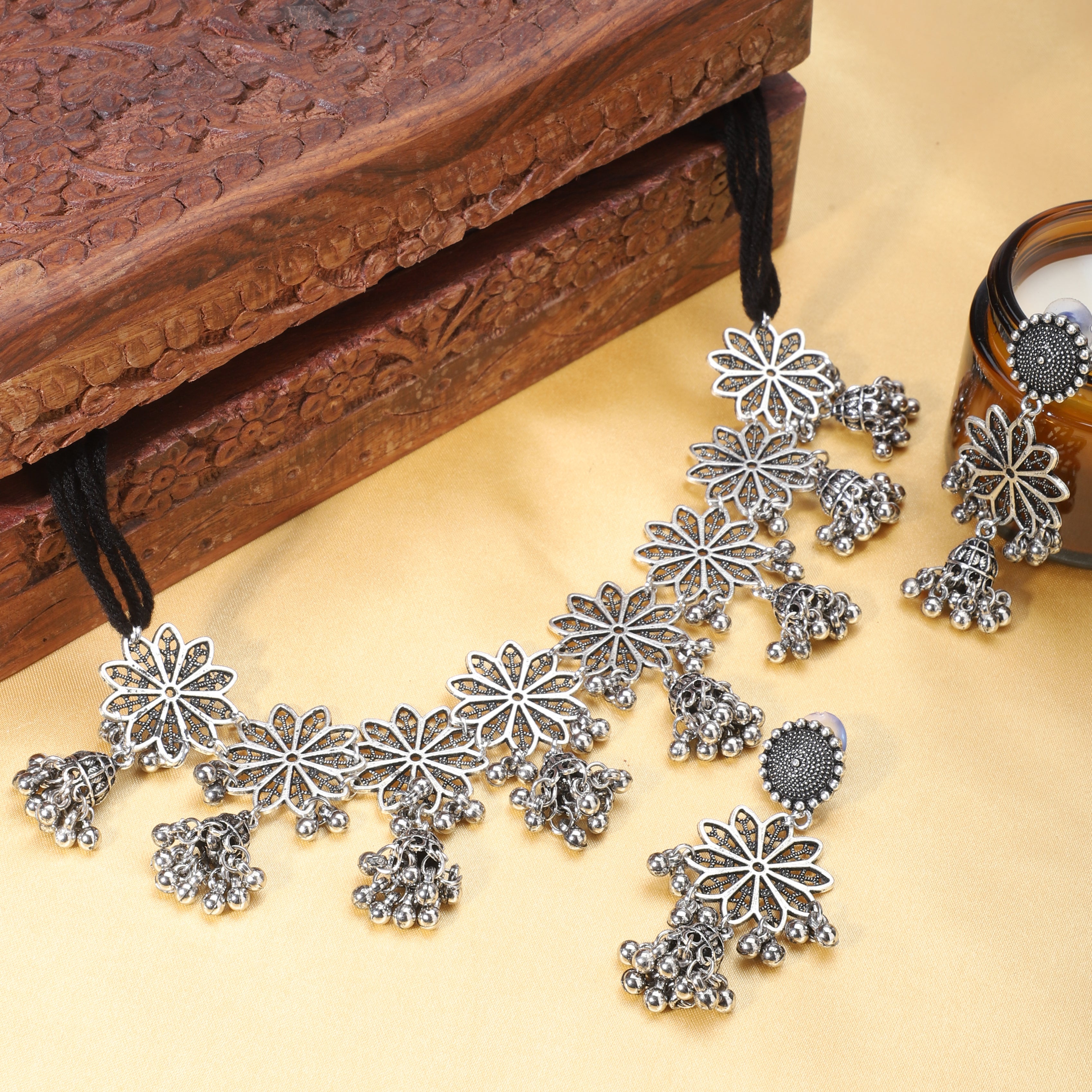 Charming oxidized short necklace set with intricate flower designs, studded with detailed accents.