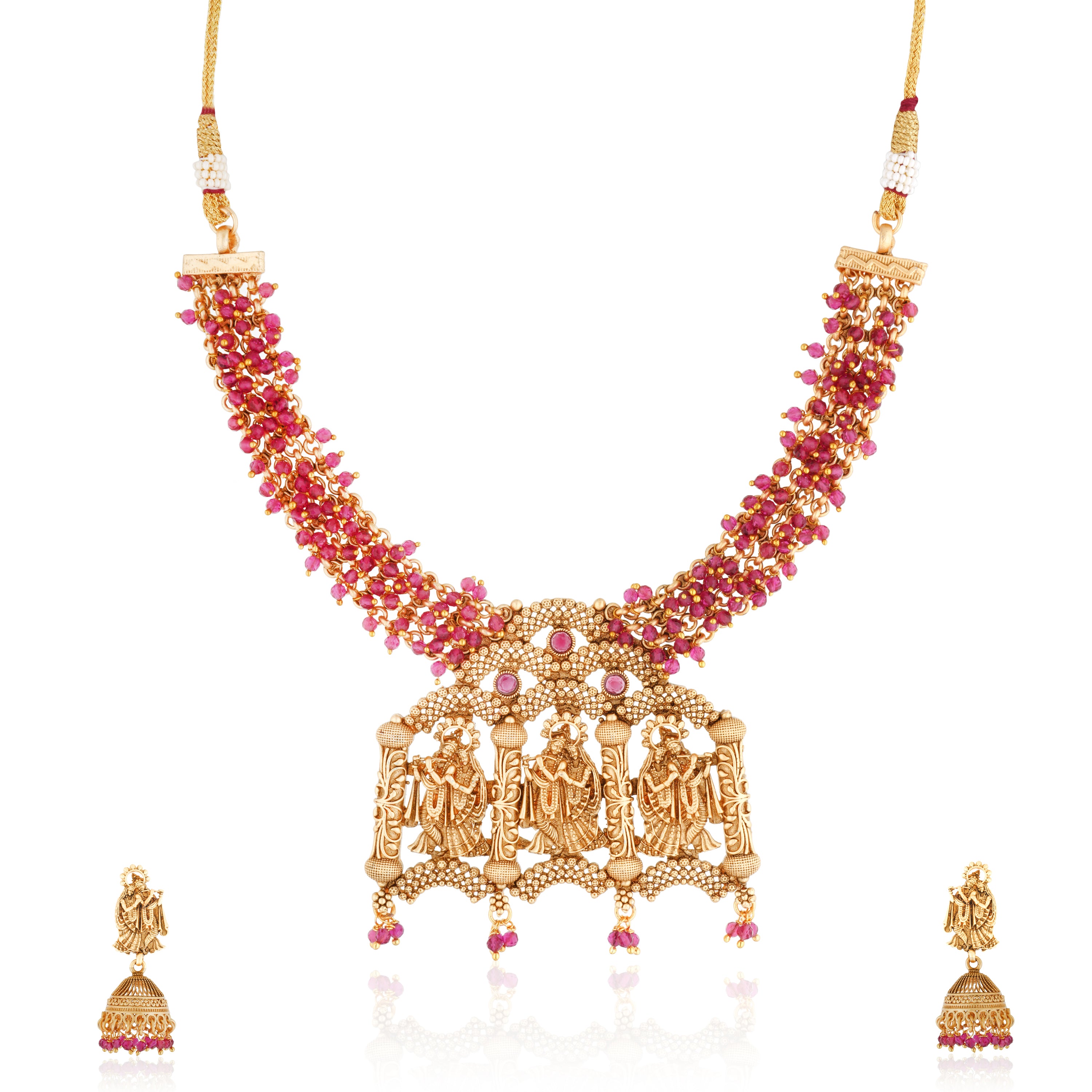 Radha Krishna temple necklace set with red pearls, showcasing intricate gold-tone craftsmanship.