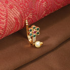 Kundan-studded goldtone nosepin with intricate detailing and a classic goldtone finish.
