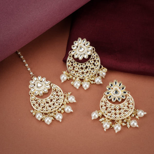 "Classic silver Kundan and pearl-studded earrings with matching Maang Tikka for festive elegance."