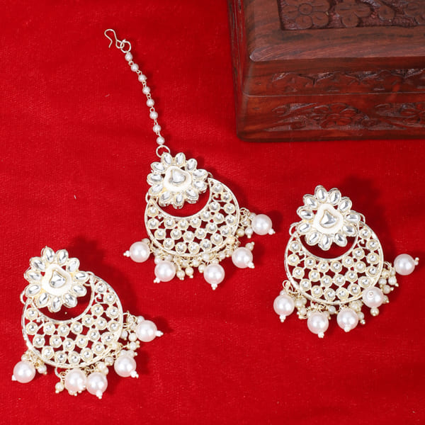 "Classic silver Kundan and pearl-studded earrings with matching Maang Tikka for festive elegance."