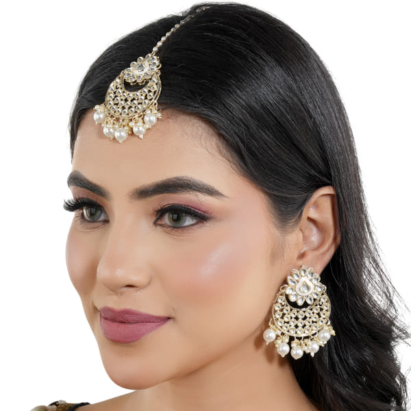 "Classic silver Kundan and pearl-studded earrings with matching Maang Tikka for festive elegance."