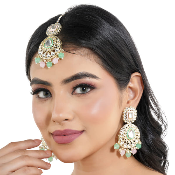 "Festive Kundan and multicolor pearl earrings with matching Maang Tikka, offering an elegant look."