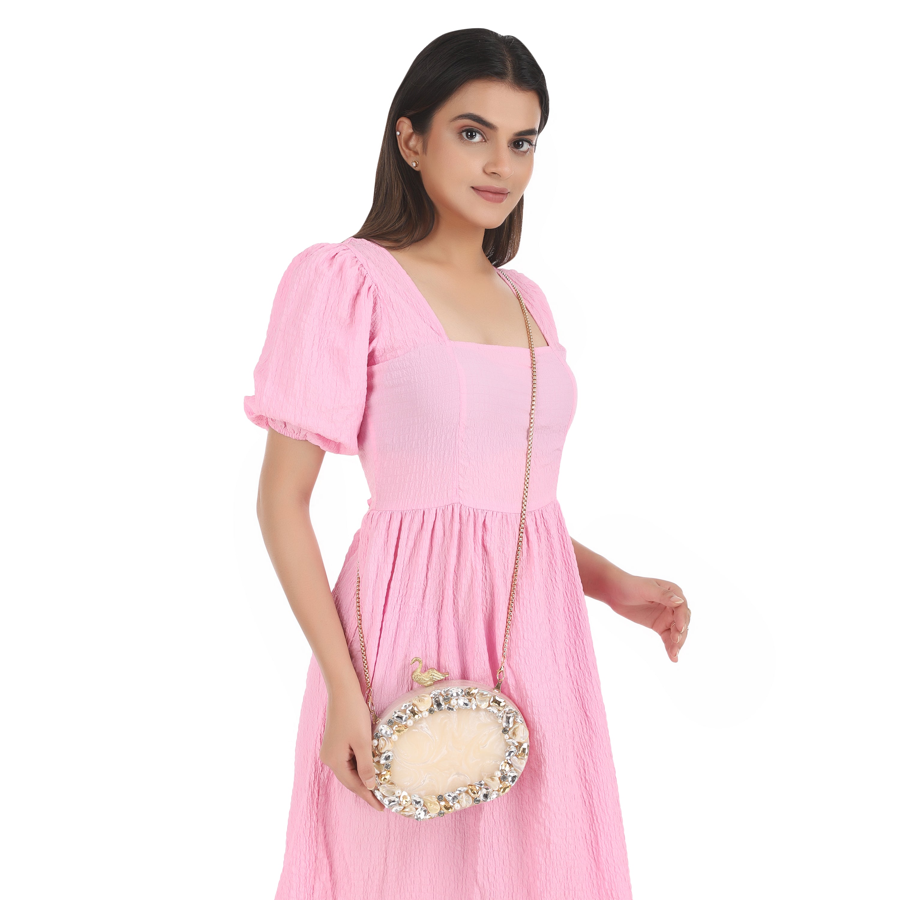 Oval-shaped salmon resin clutch with peacock design closure and sleek sling chain for style.