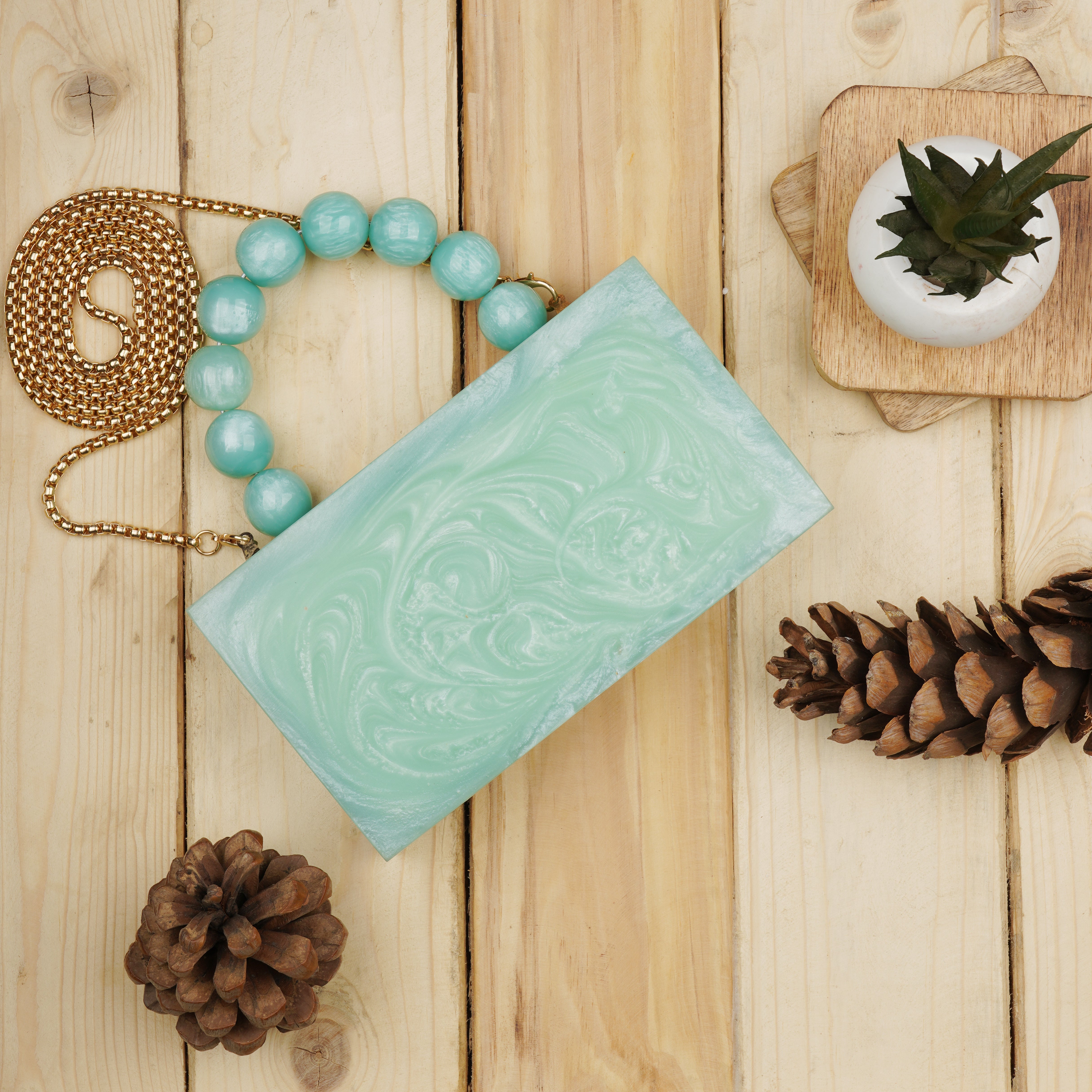 Green resin clutch with velvet lining, heavy-duty sling, and extra pocket for stylish storage.