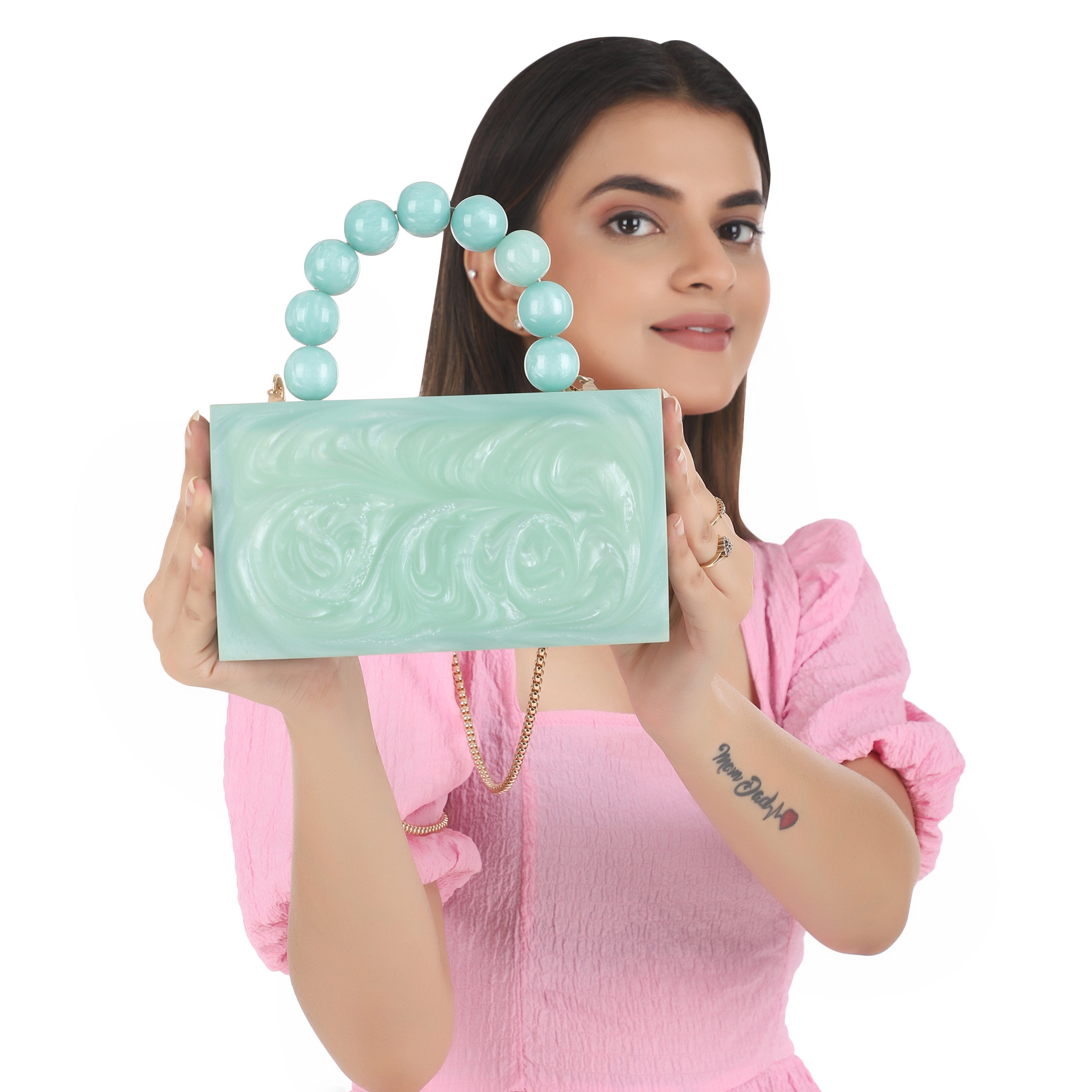 Green resin clutch with velvet lining, heavy-duty sling, and extra pocket for stylish storage.