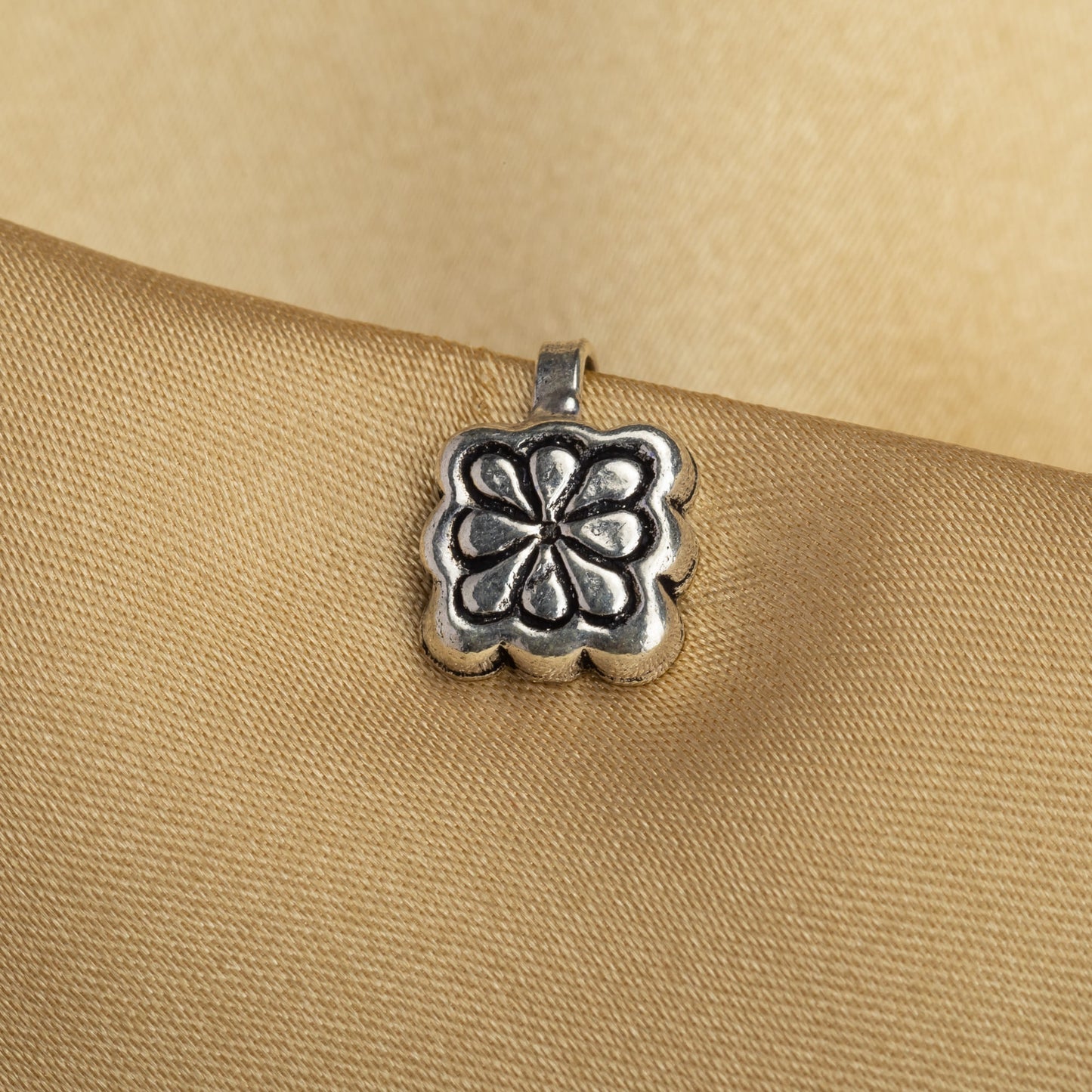 A SMALL OXIDIZED NOSE PIN ADDS A REFINED, RETRO CHARM WITH ITS UNDERSTATED, DARKENED FINISH.