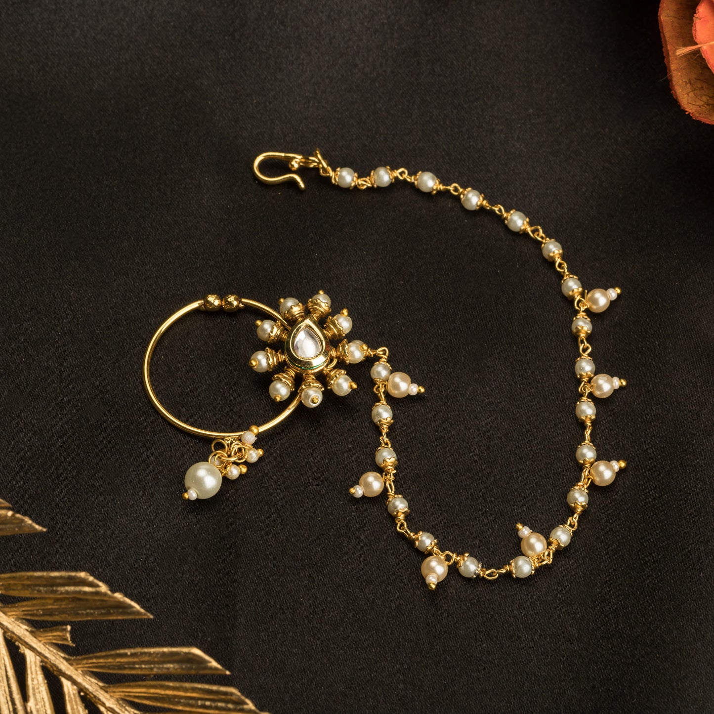 A GOLD-TONE NOSE RING NATH WITH PEARLS OFFERS AN ELEGANT BLEND OF TRADITIONAL DESIGN AND CLASSIC SOPHISTICATION.