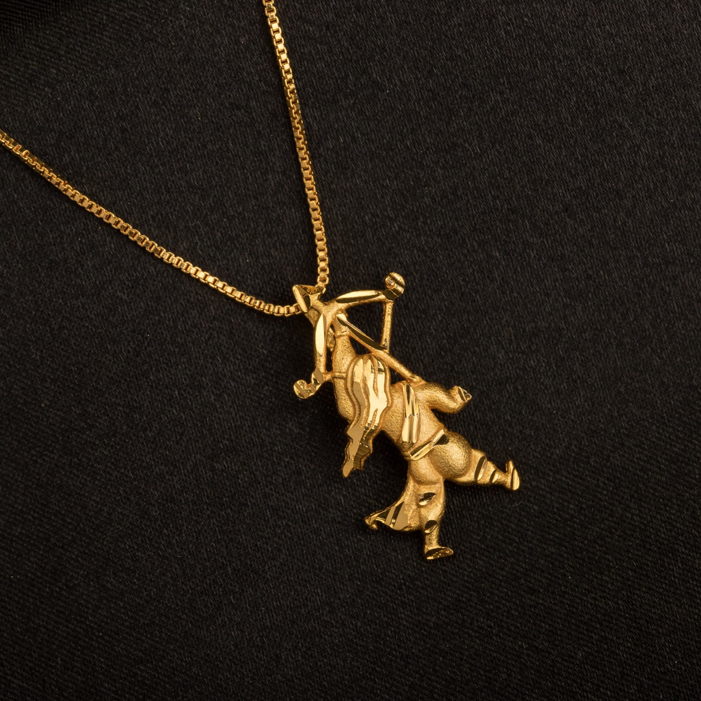 GOLD-TONE PENDANT OF A BOY WITH A BOW (DHANUSH).