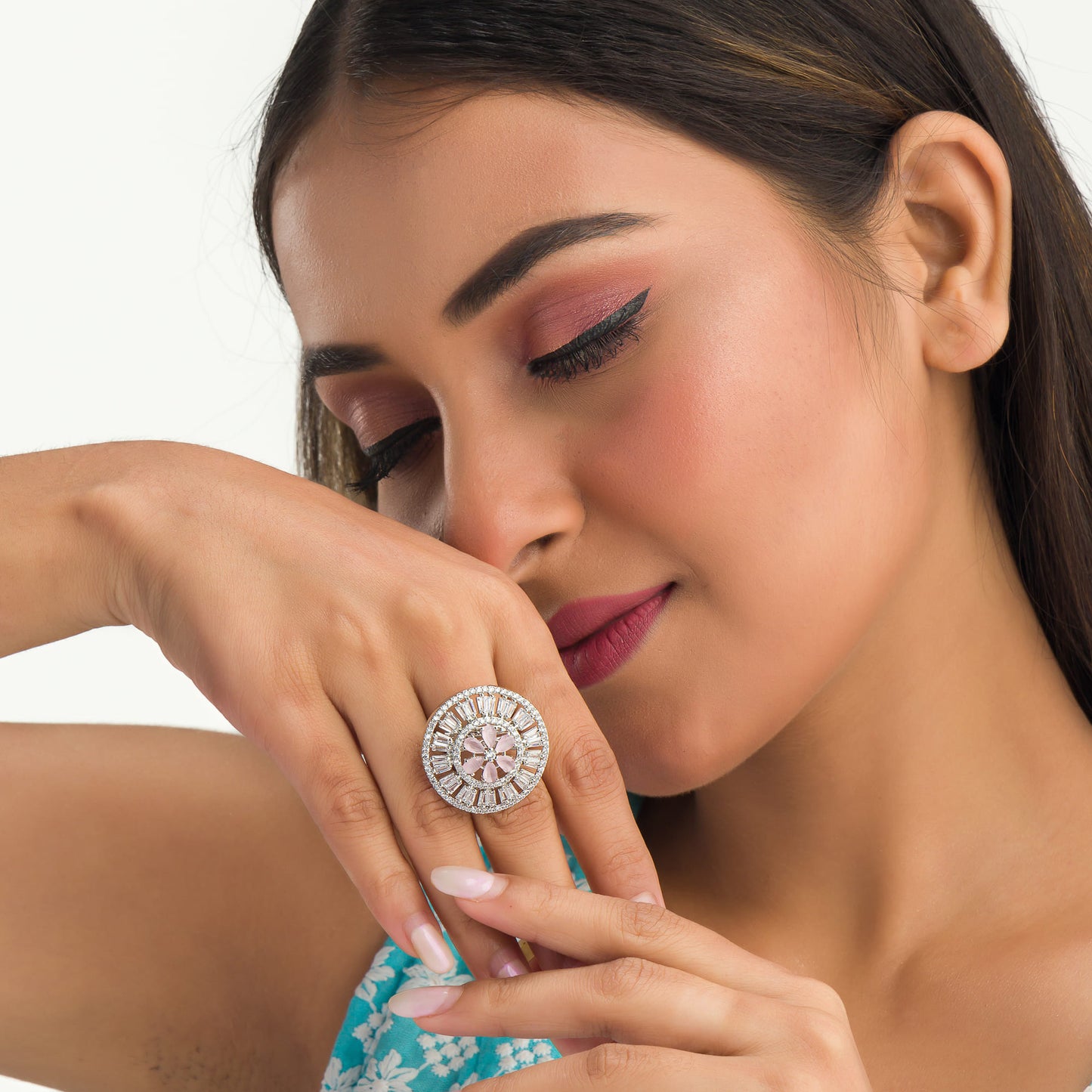 A ZIRCON FINGER RING WITH A PINK FLOWER IN THE MIDDLE COMBINES SPARKLING ELEGANCE WITH A CHARMING, VIBRANT FOCAL POINT.