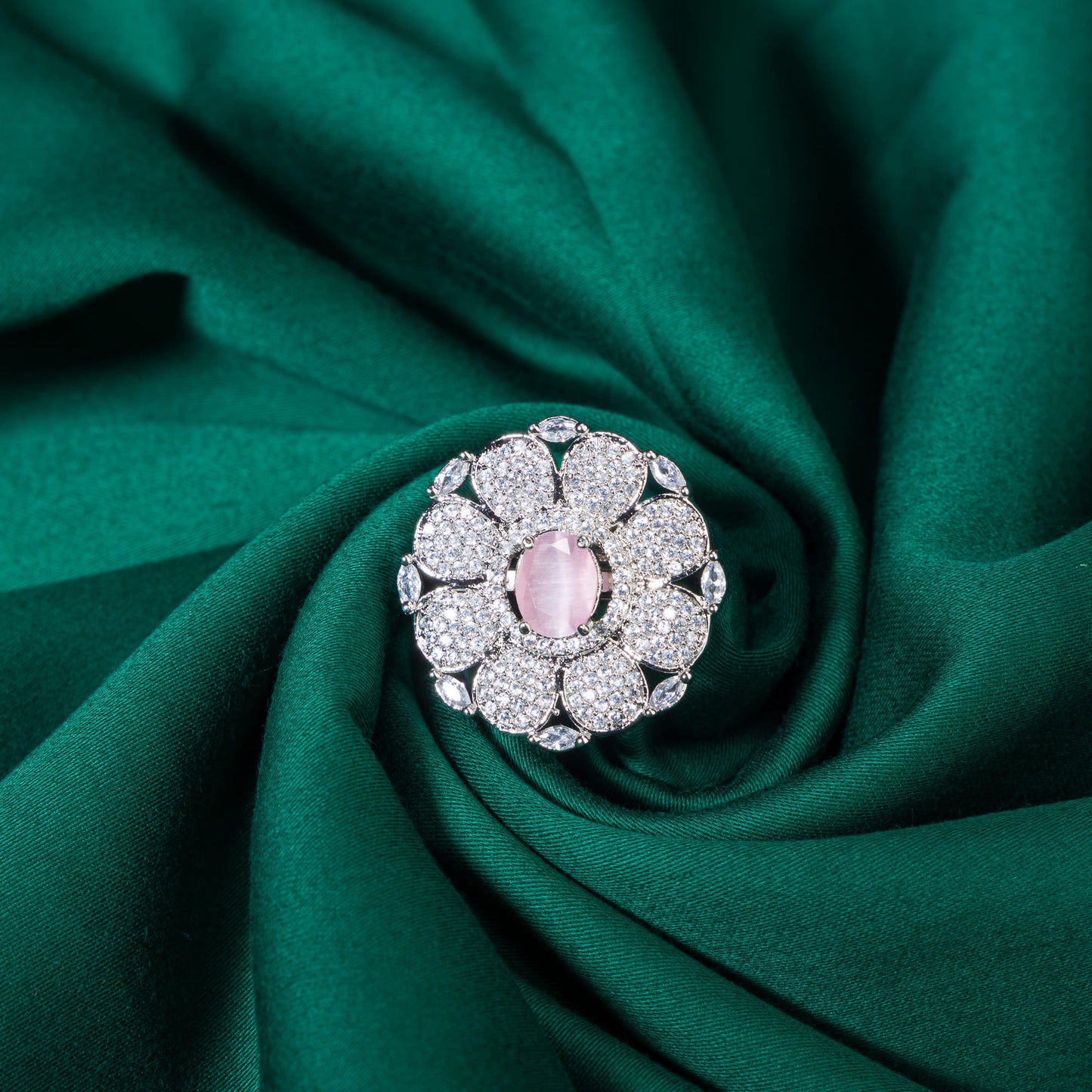 A ZIRCON FINGER RING WITH A PINK FLOWER IN THE MIDDLE COMBINES SPARKLING ELEGANCE WITH A CHARMING, VIBRANT FOCAL POINT.