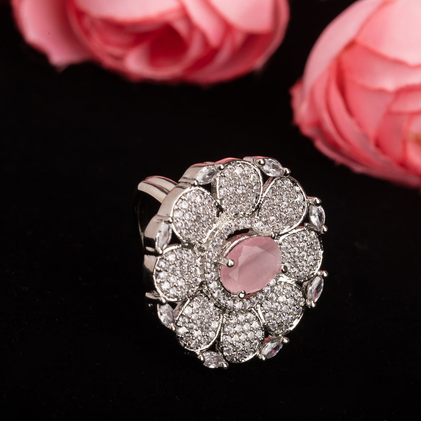 A ZIRCON FINGER RING WITH A PINK FLOWER IN THE MIDDLE COMBINES SPARKLING ELEGANCE WITH A CHARMING, VIBRANT FOCAL POINT.