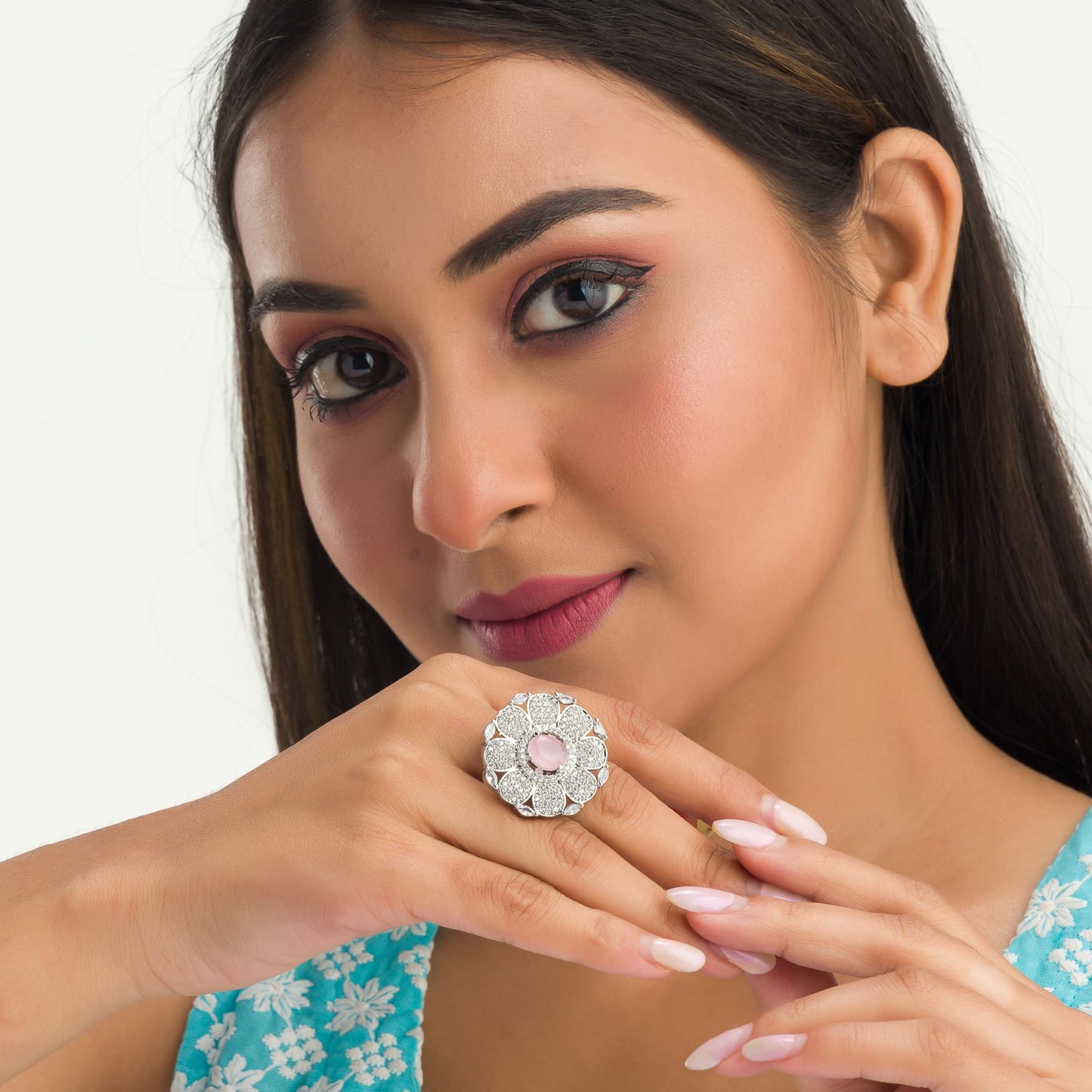 A ZIRCON FINGER RING WITH A PINK FLOWER IN THE MIDDLE COMBINES SPARKLING ELEGANCE WITH A CHARMING, VIBRANT FOCAL POINT.