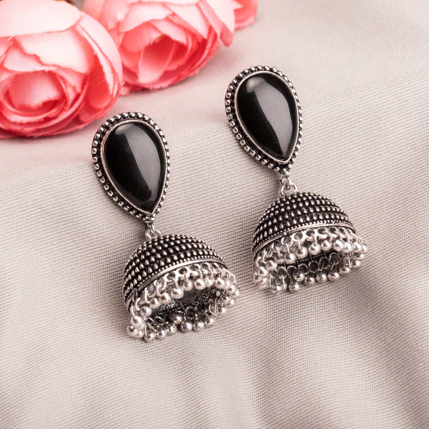 "OXIDIZED JHUMKA WITH A BLACK STONE AT THE CENTER DELIVERS A STRIKING, VINTAGE ALLURE."