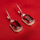 "Dark red zircon dangler earrings in rose gold offer a bold, sophisticated touch for party wear."
